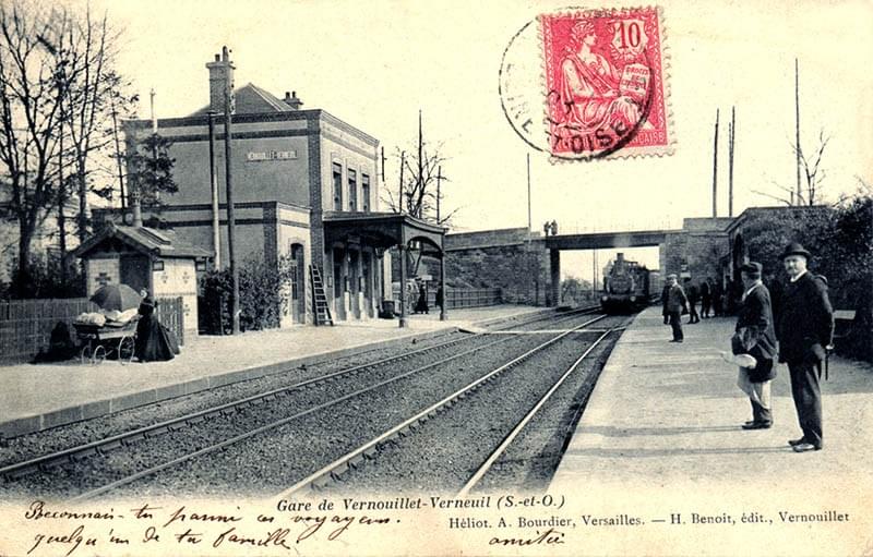 Carte postale de la gare de Vernouillet, envoyée en 1903. L’homme au parapluie accroché dans le dos, au tout premier plan à droite, n’est autre Carte postale de la gare de Vernouillet, envoyée en 1903. L’homme au parapluie accroché dans le dos, au tout premier plan à droite, n’est autre