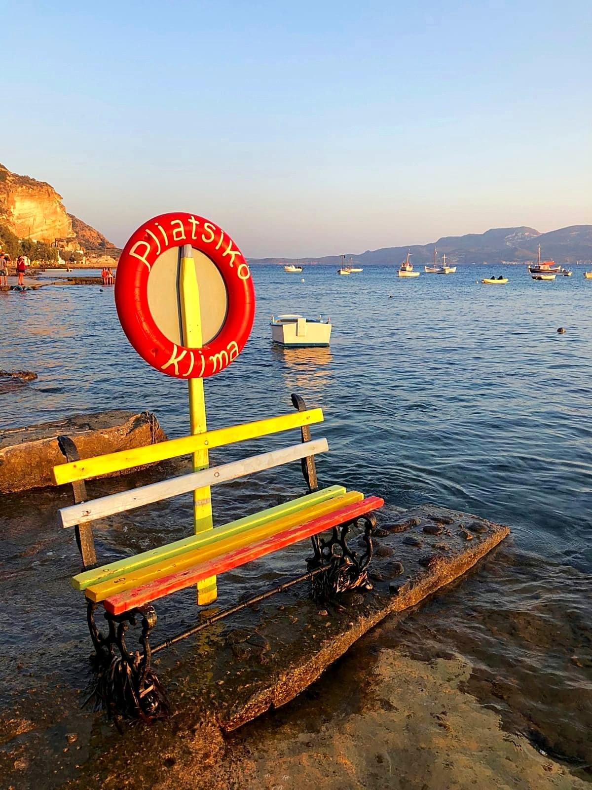 Colorful bench in front of seaview with boats Colorful bench in front of seaview with boats