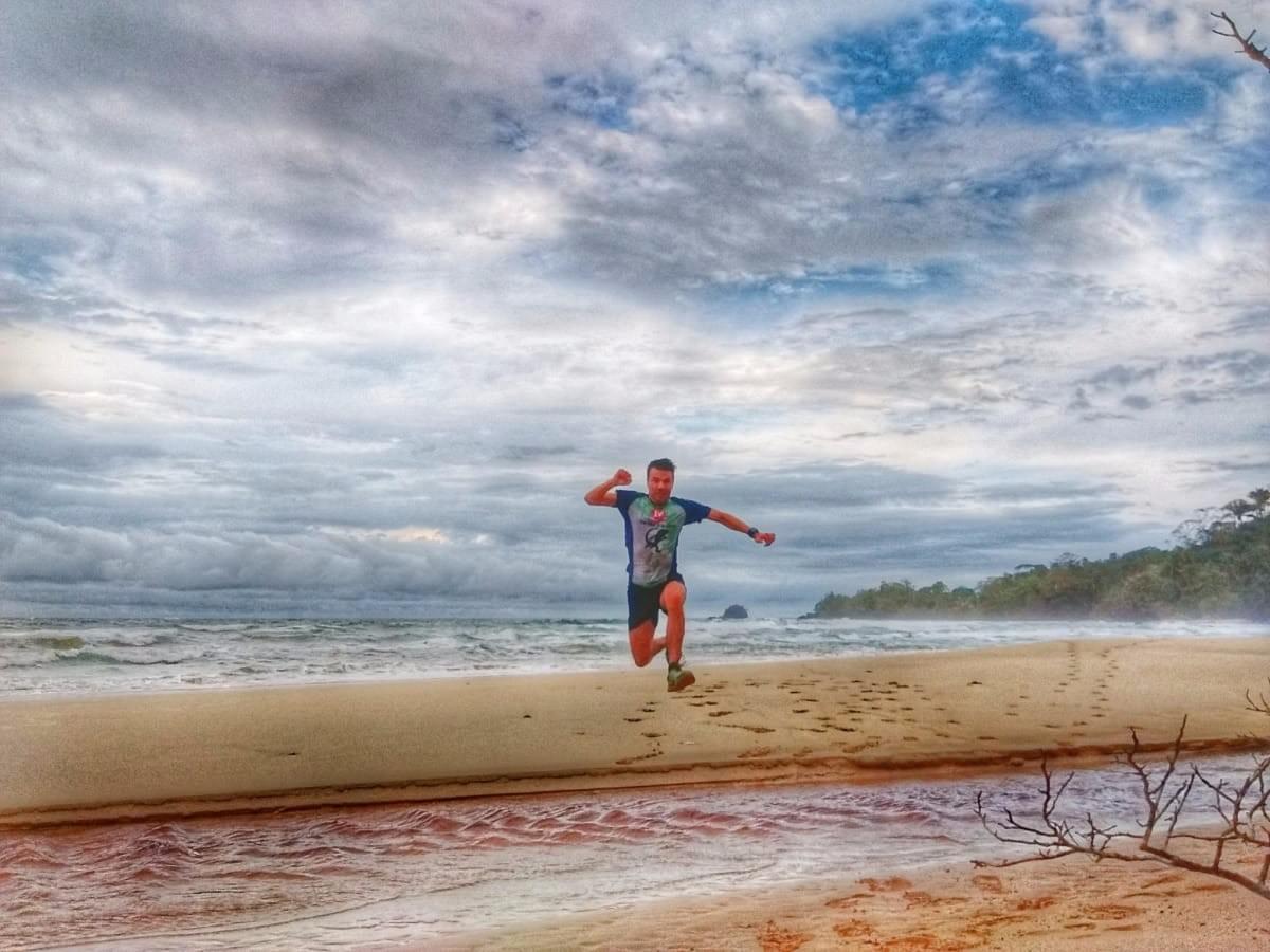 Jumping over a creek on Wizard Beach, Bastimentos Island, Panama Jumping over a creek on Wizard Beach, Bastimentos Island, Panama