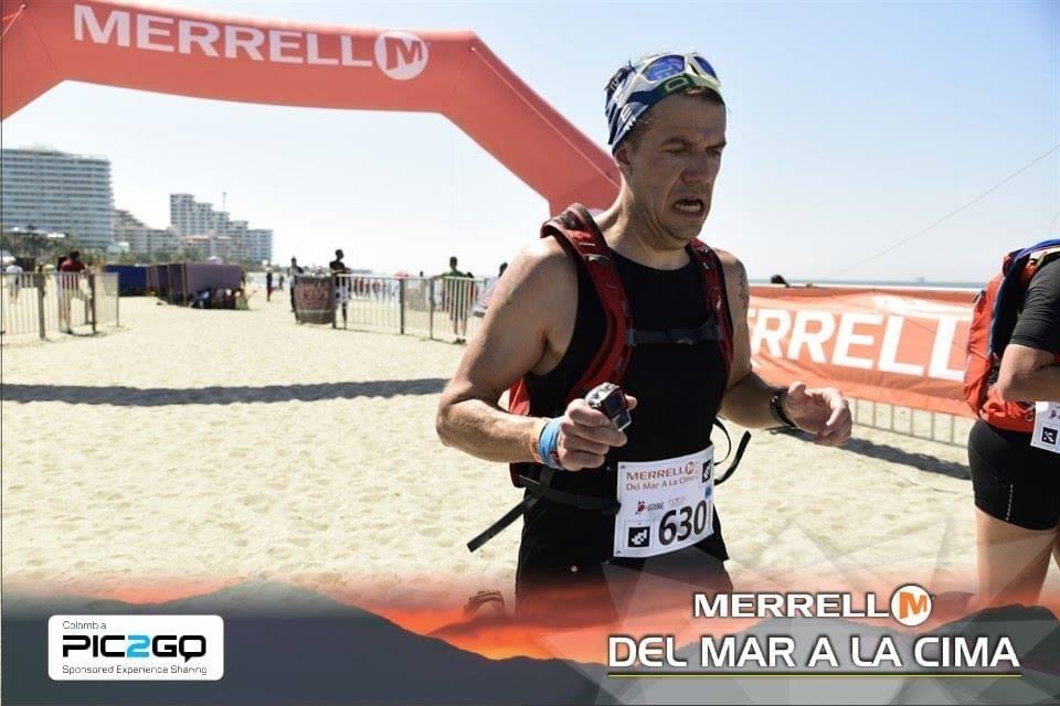 A runner crosses the finish line at Del Mar a La Cima ultra marathon, a pained look on his face A runner crosses the finish line at Del Mar a La Cima ultra marathon, a pained look on his face