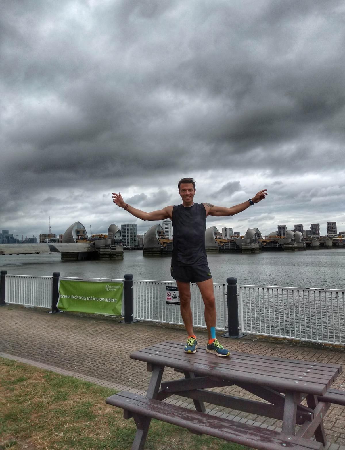 Runner poses for a celebration photo in front of the Thames Barrier, conclusion of the Thames Path Runner poses for a celebration photo in front of the Thames Barrier, conclusion of the Thames Path