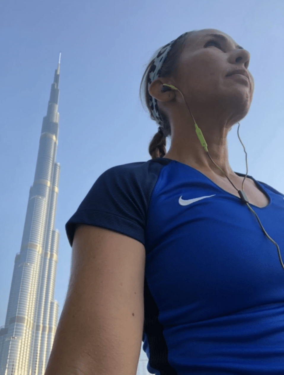 female runner poses in front of burj khalifa dubai UAE female runner poses in front of burj khalifa dubai UAE