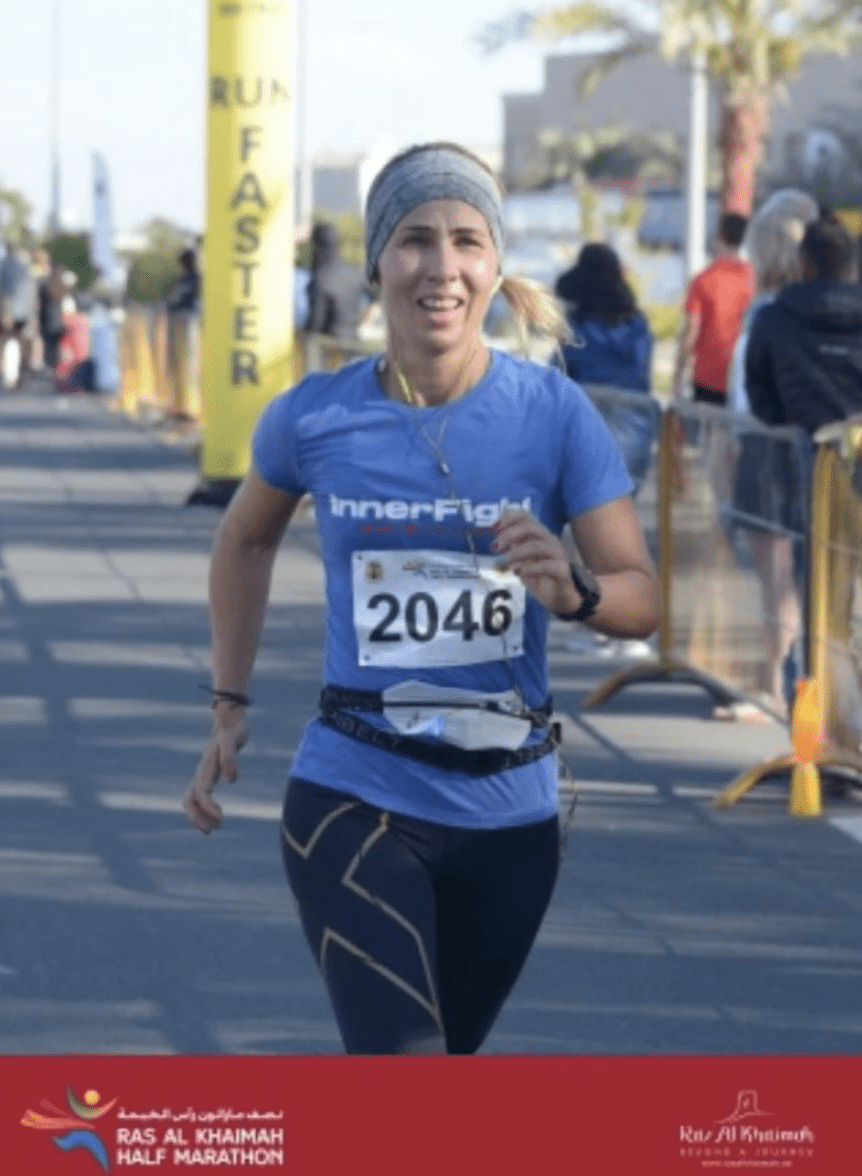 female runner crossing the finish line at ras al khaimah half marathon female runner crossing the finish line at ras al khaimah half marathon