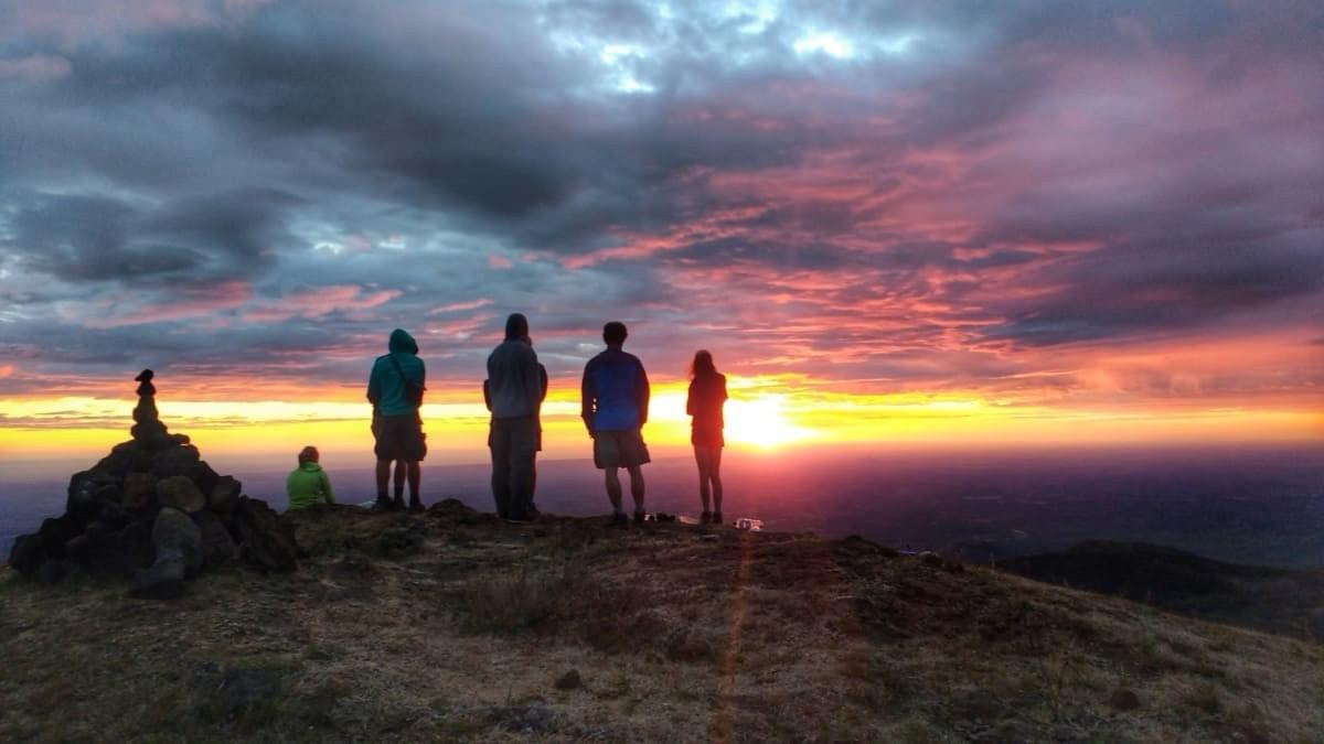 A group of Queztaltrekkers hikers view a spectacular sunset from the top of a volcano A group of Queztaltrekkers hikers view a spectacular sunset from the top of a volcano