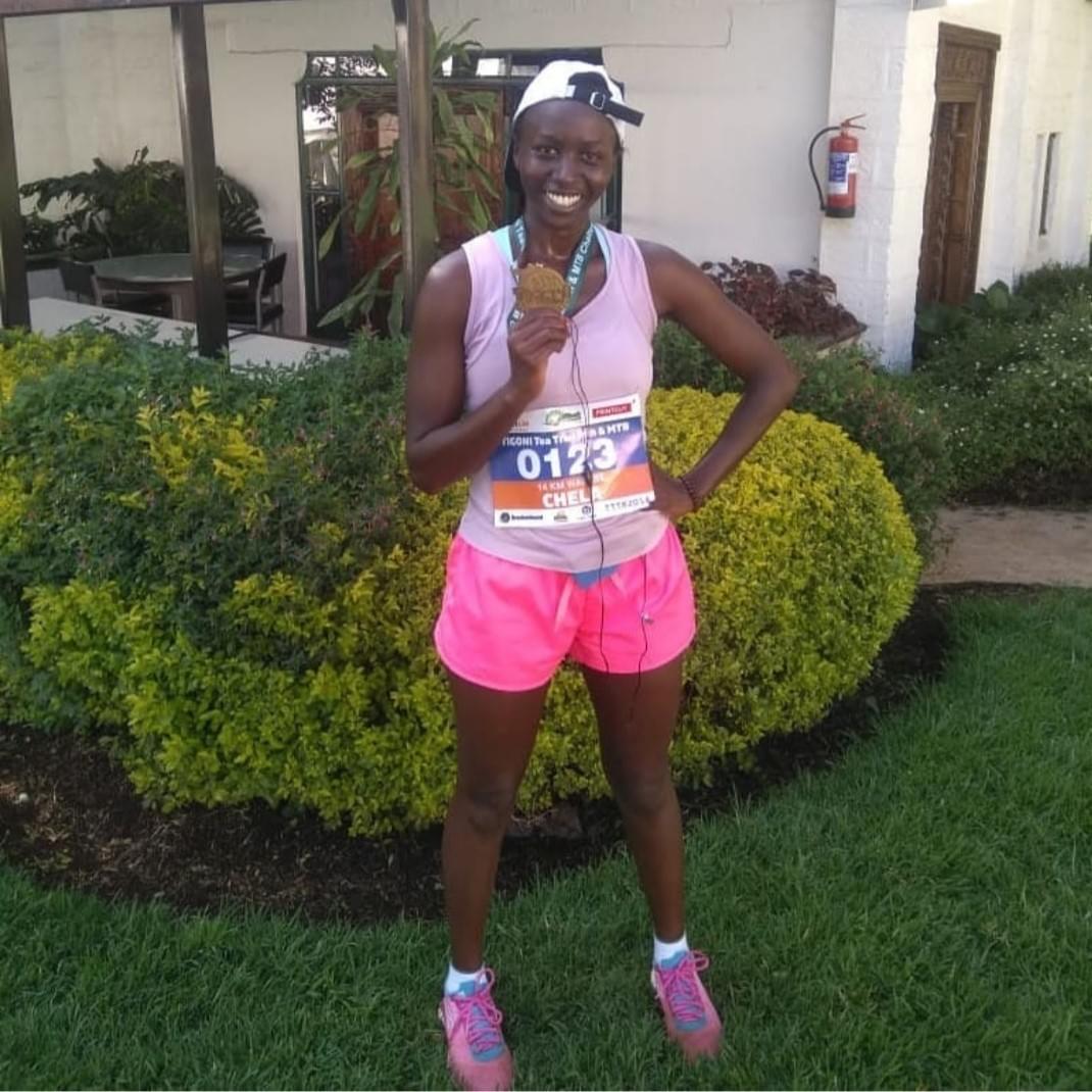 Running in Nairobi, a runner with a finish medal from the Tigoni Trails race in Kenya Running in Nairobi, a runner with a finish medal from the Tigoni Trails race in Kenya