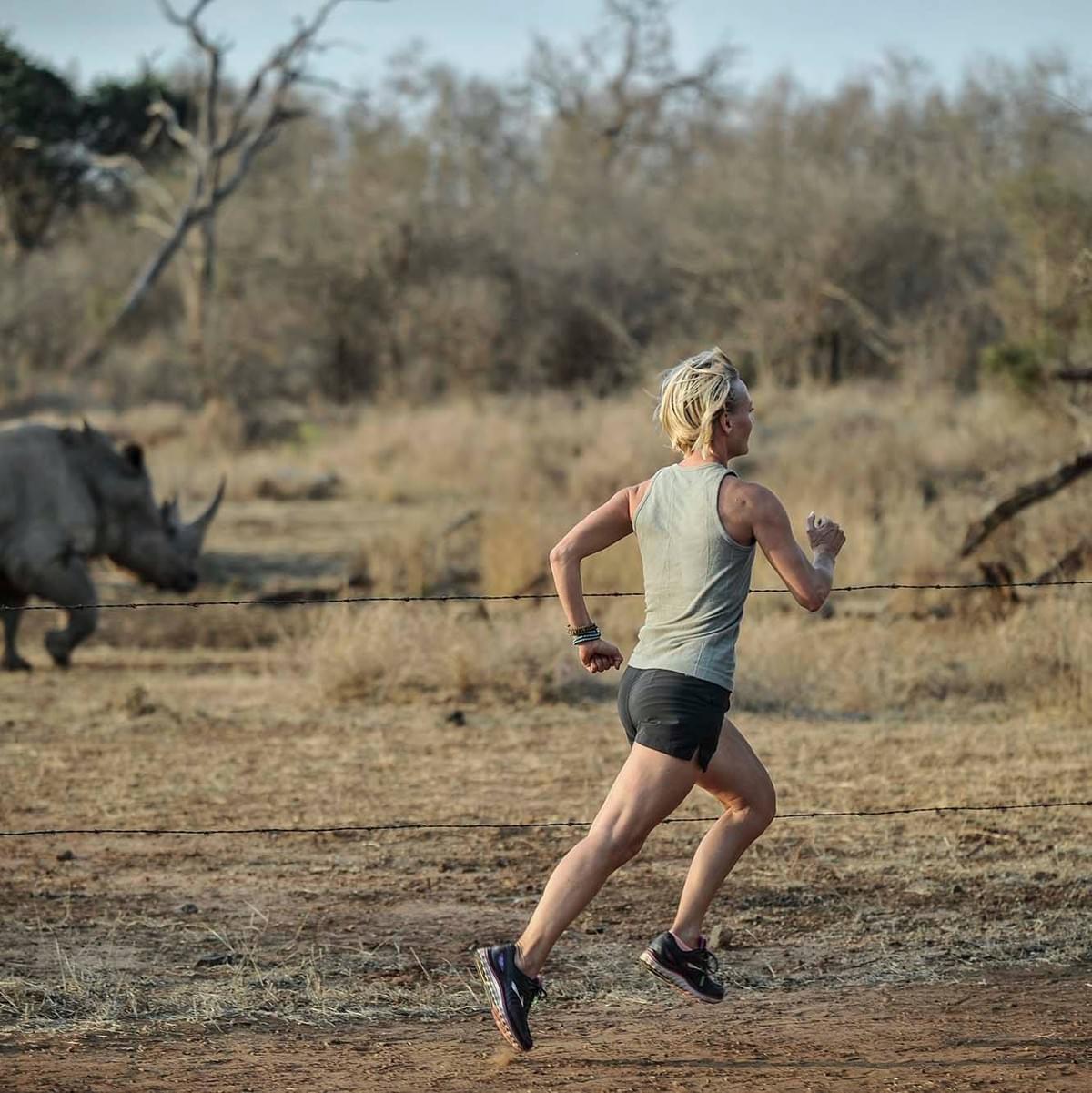 a female runner runs amongst rhino in Swaziland / Eswatini (photo credit: Mujahid Safodien) a female runner runs amongst rhino in Swaziland / Eswatini (photo credit: Mujahid Safodien)