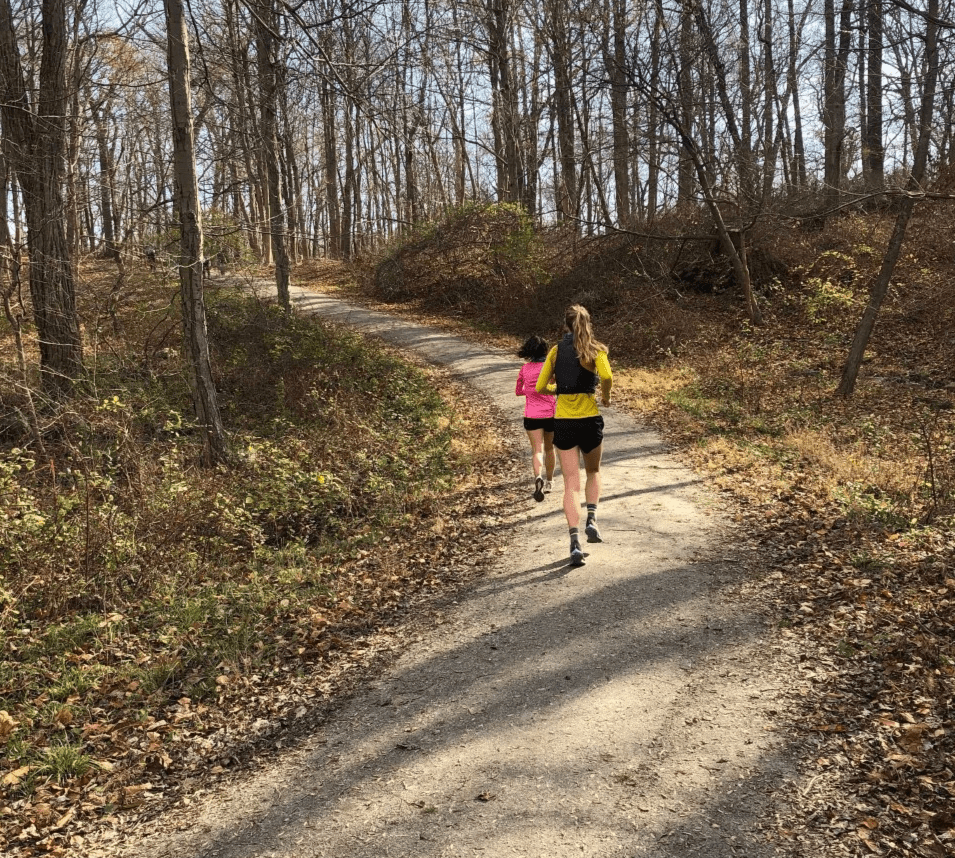 Two female New York runners running a woodland trail in a New York park Two female New York runners running a woodland trail in a New York park