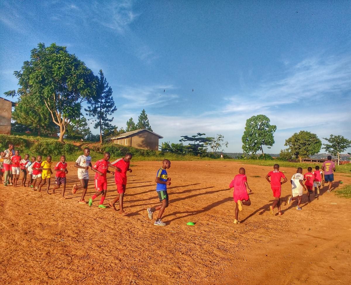 Local children take part in a running session on a dirt pitch in rural Uganda Local children take part in a running session on a dirt pitch in rural Uganda