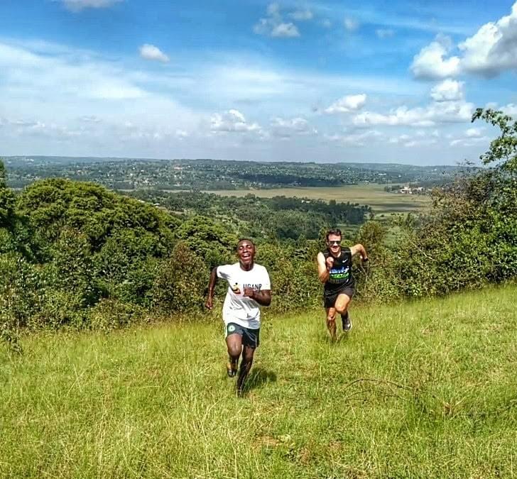 A local boy laughs as he beats a runner on a hill climb on a ridge above lush countryside in Masaka, Uganda A local boy laughs as he beats a runner on a hill climb on a ridge above lush countryside in Masaka, Uganda