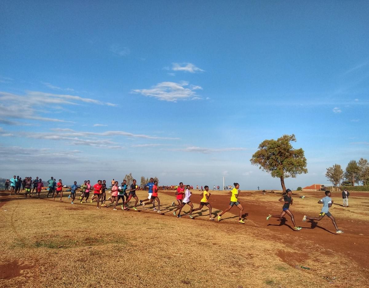 A large group of female Ugandan runners on an interval training session on a thin dirt track in Kapchorwa town A large group of female Ugandan runners on an interval training session on a thin dirt track in Kapchorwa town