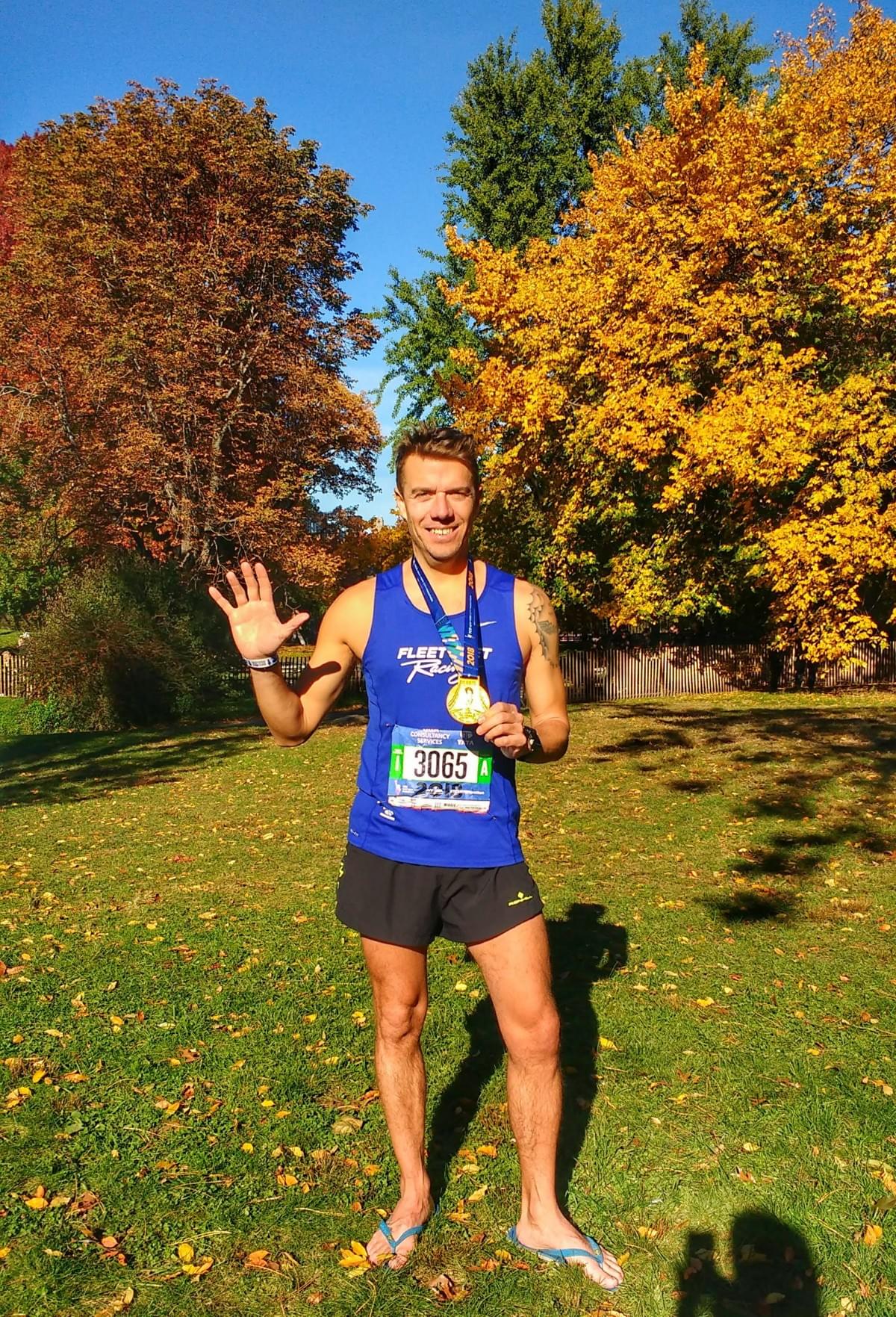 Smiling runner showing off the New York City marathon finishers medal in Central Park, New York Smiling runner showing off the New York City marathon finishers medal in Central Park, New York