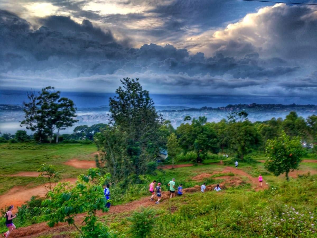 A group of Uganda Marathon 2018 runners descend on a dirt trail through trees during an early morning training run A group of Uganda Marathon 2018 runners descend on a dirt trail through trees during an early morning training run