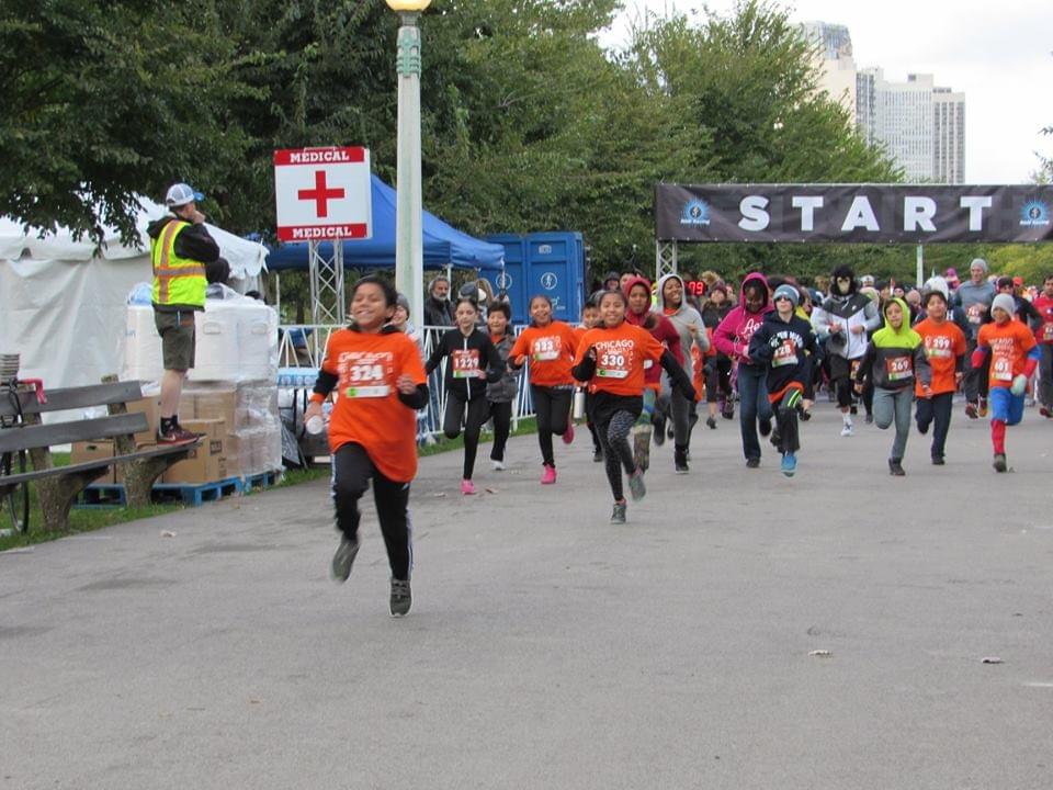 A group of young runners excitedly sprint away at the start of the 'Pumpkins in the Park' in Lincoln Park, Chicago A group of young runners excitedly sprint away at the start of the 'Pumpkins in the Park' in Lincoln Park, Chicago