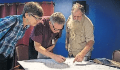 Andy and Mary Wier help landowner Lewis Sharpte find his property on Andy's maps. Andy and Mary Wier help landowner Lewis Sharpte find his property on Andy's maps.