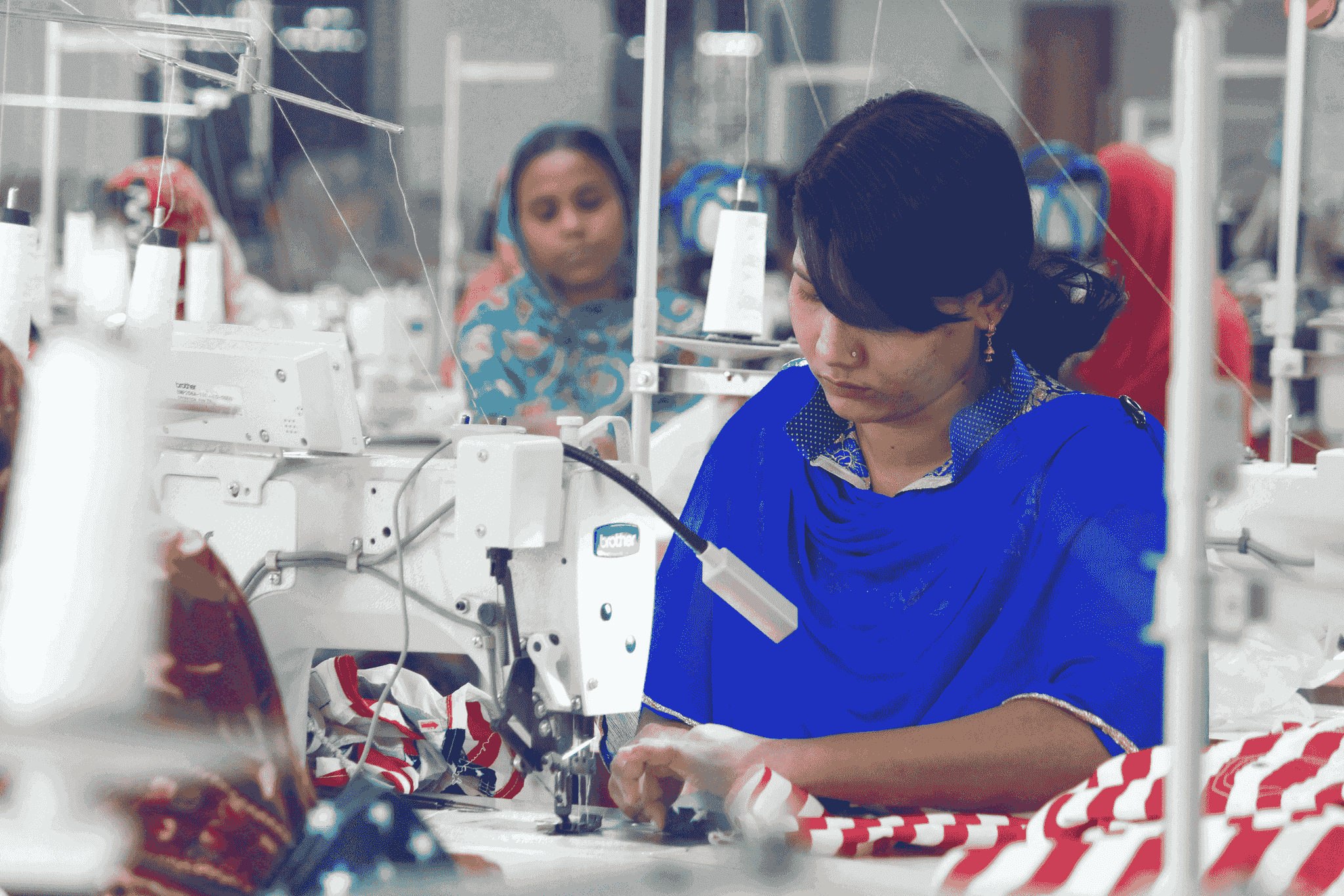 China clothing manufacturers factory workers overseeing machinery