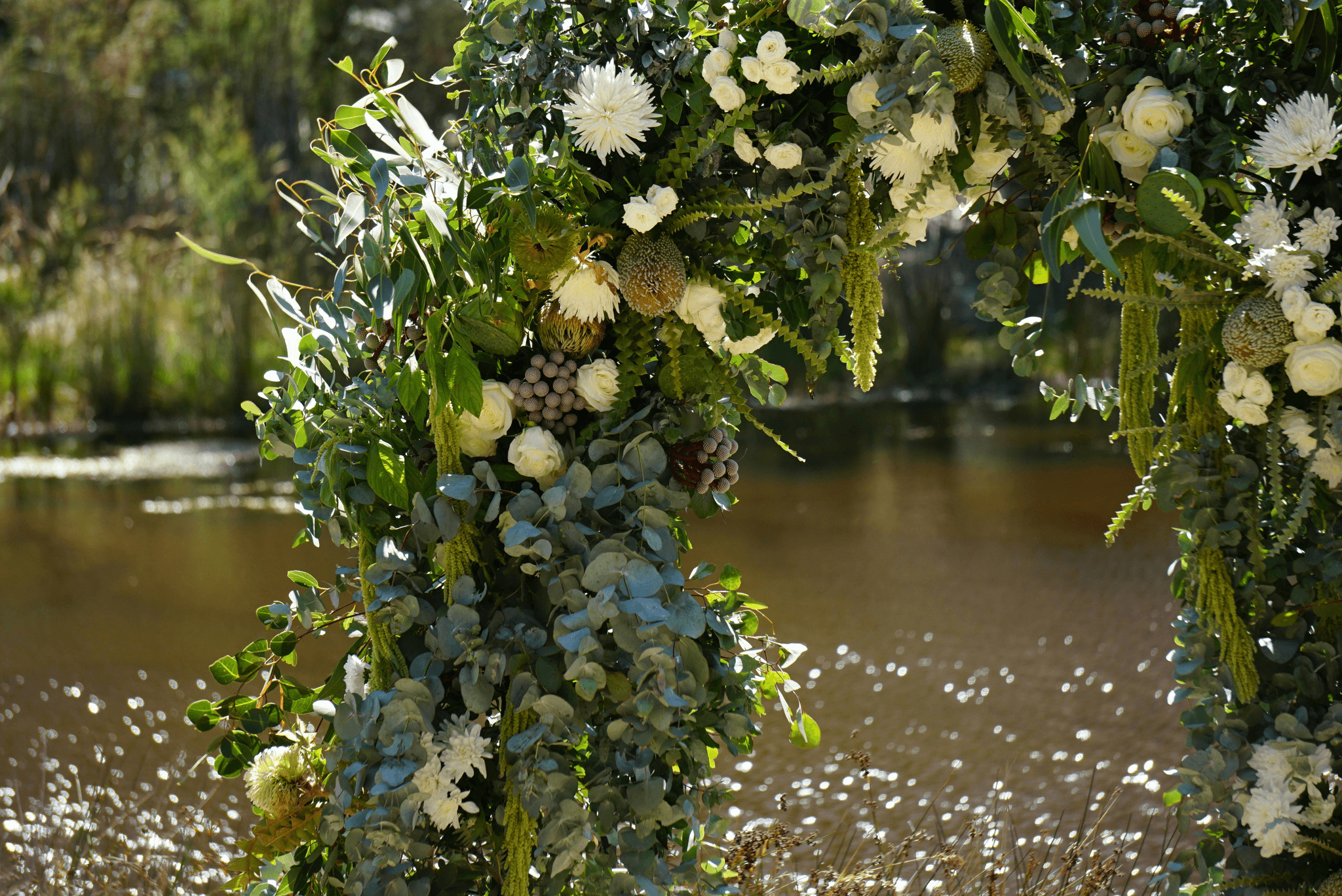 rustic wedding floral arrangements framing outdoor ceremony