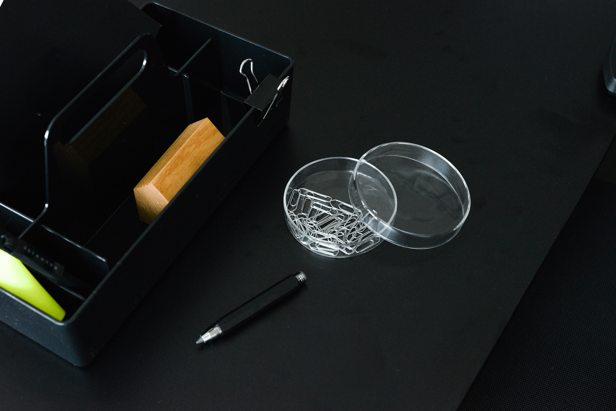 Neatly organized desk supplies in a clear capsule container