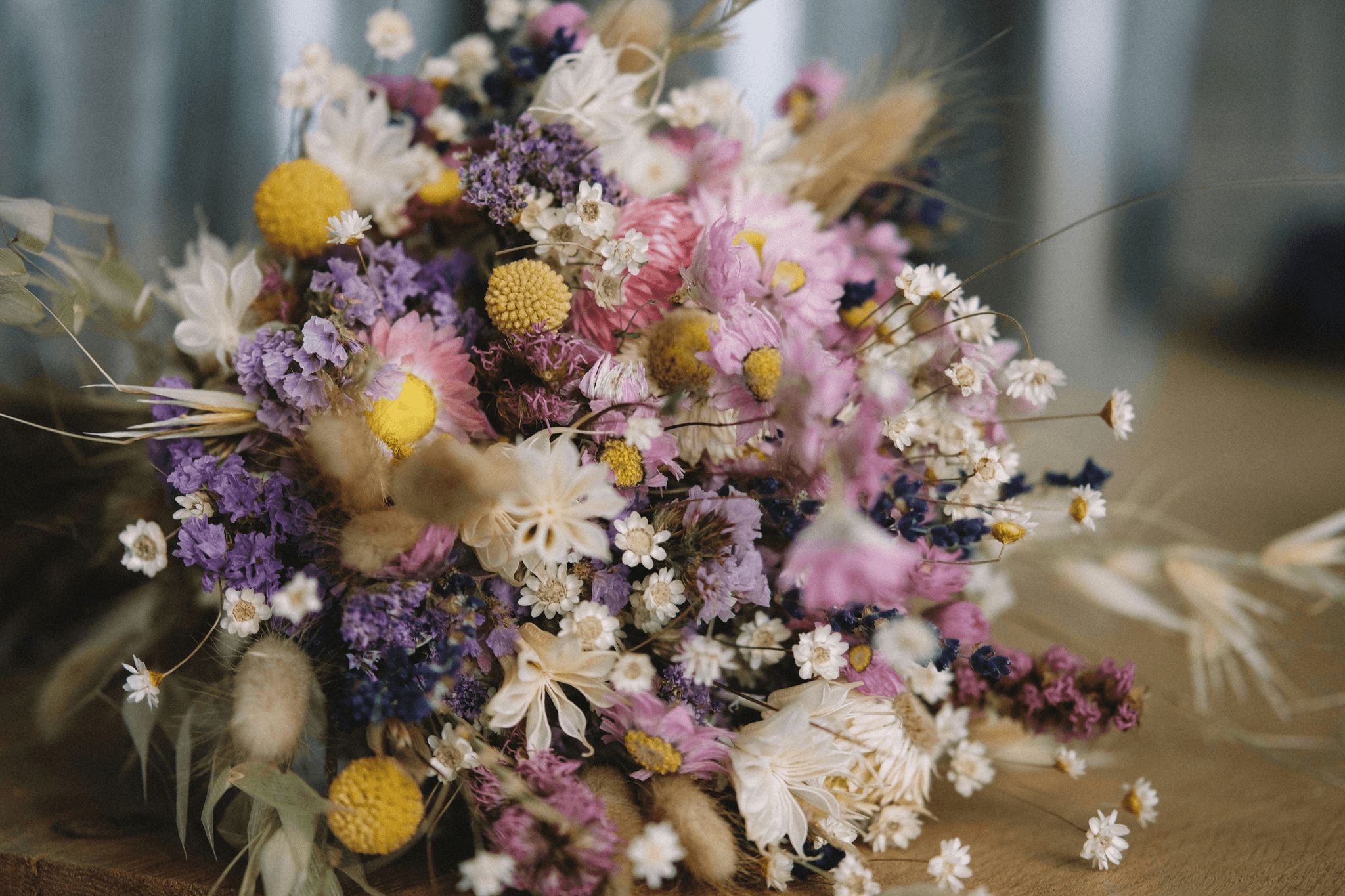 Assorted vibrant dried flower bouquet on rustic wooden table