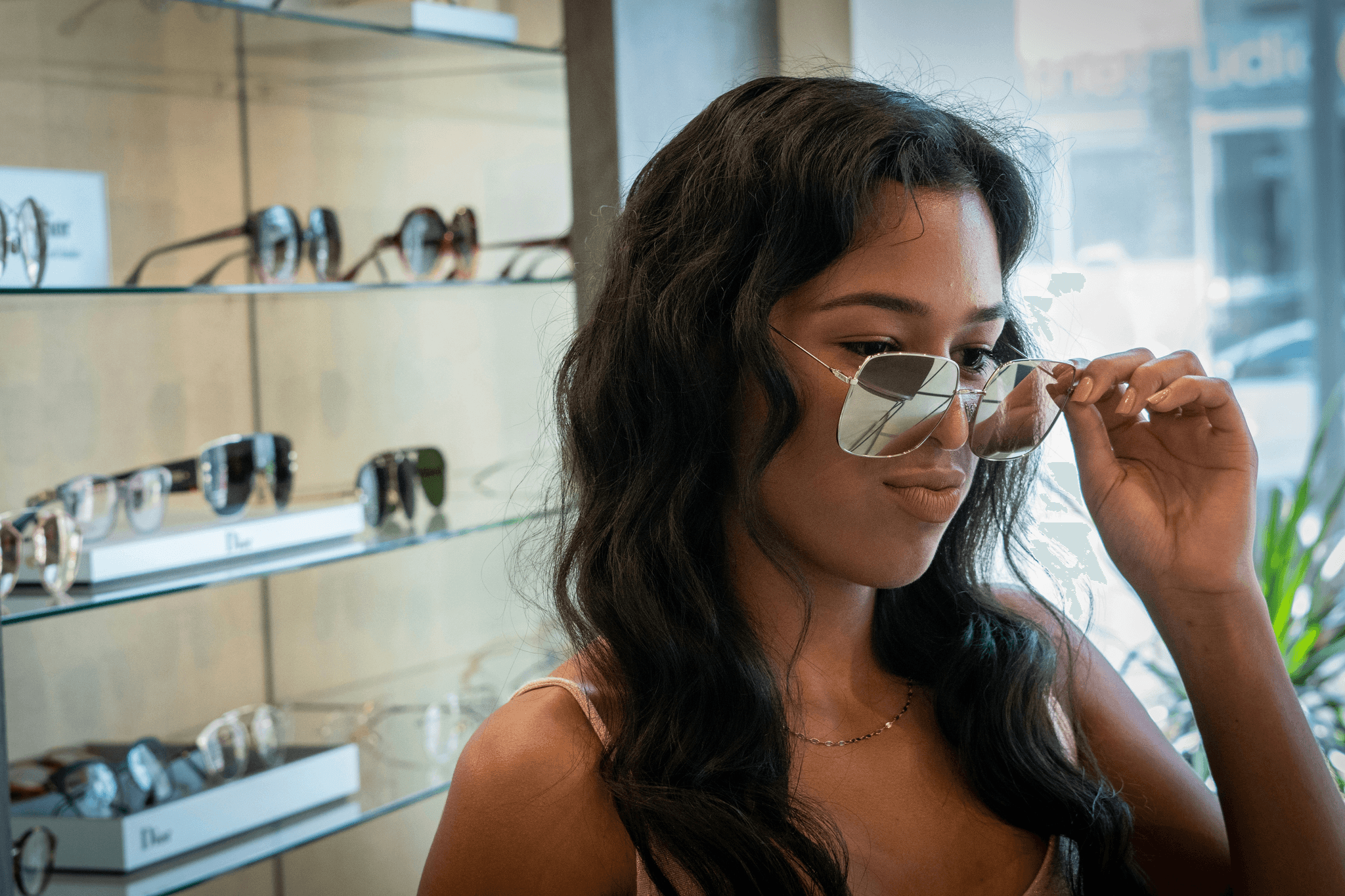 Woman wearing chic rectangle glasses at eyewear store.