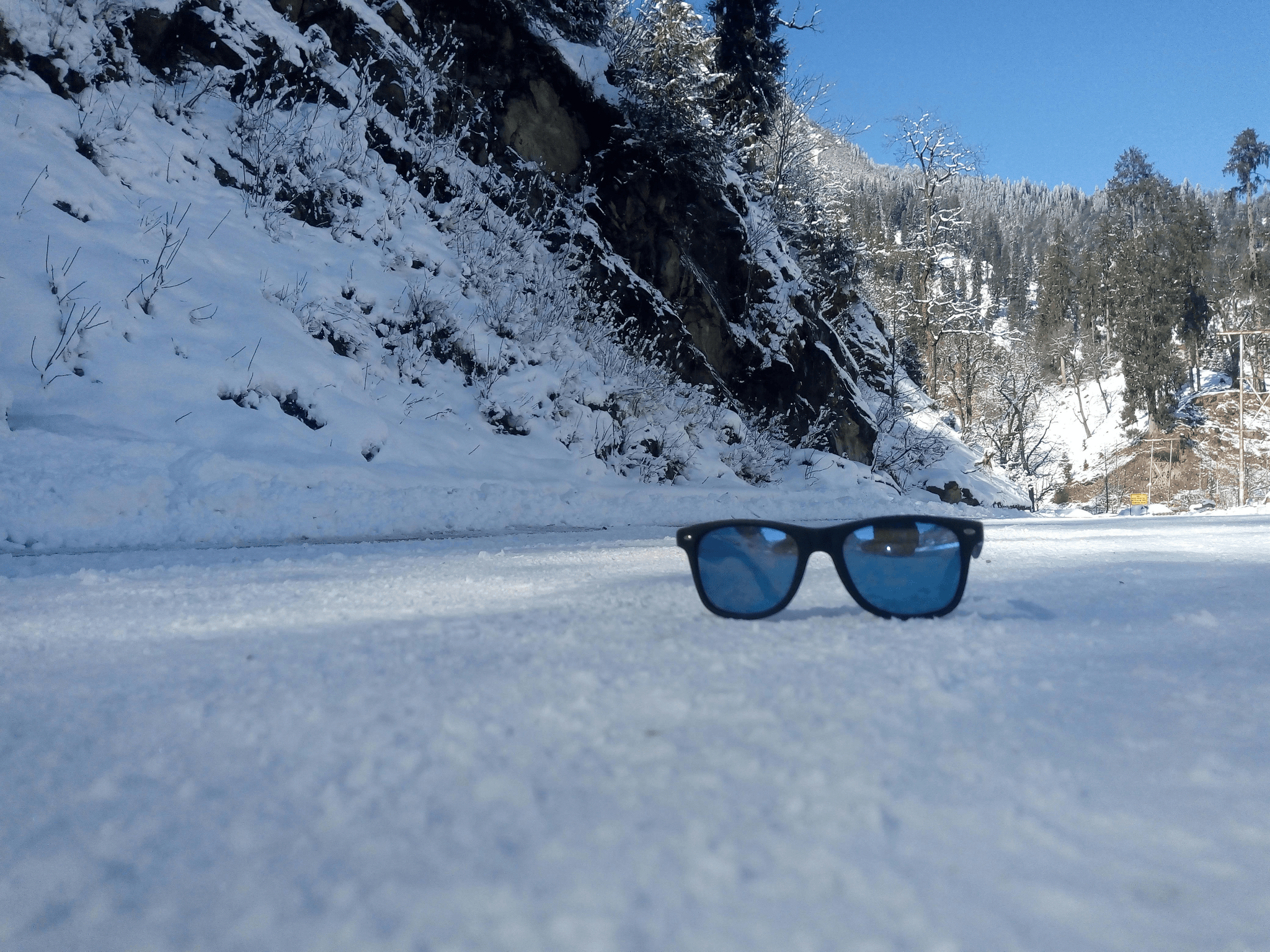 snow glasses showcased against snowy mountains background