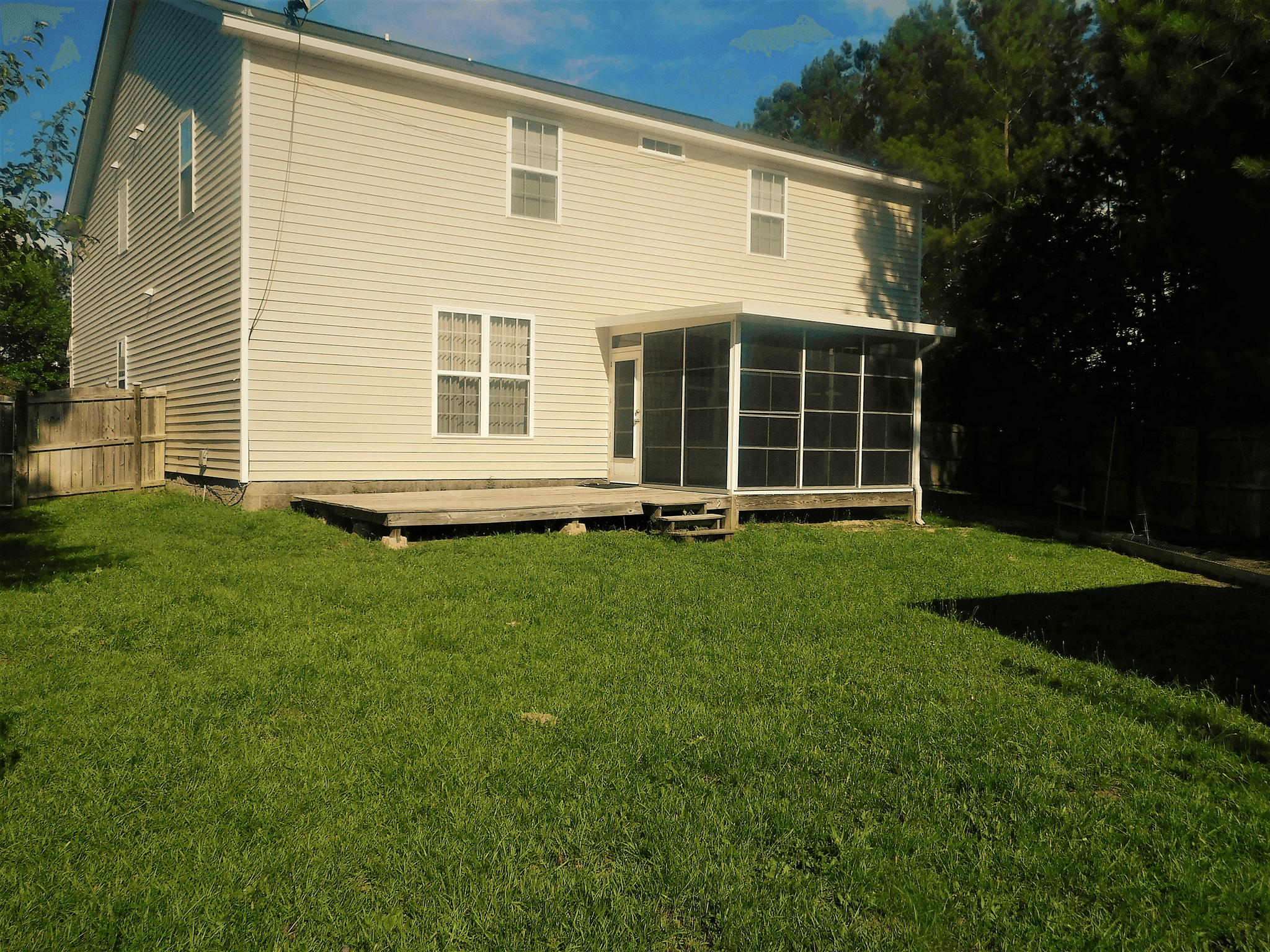 Modern mobile home with spacious porch and landscaped yard at affordable prices