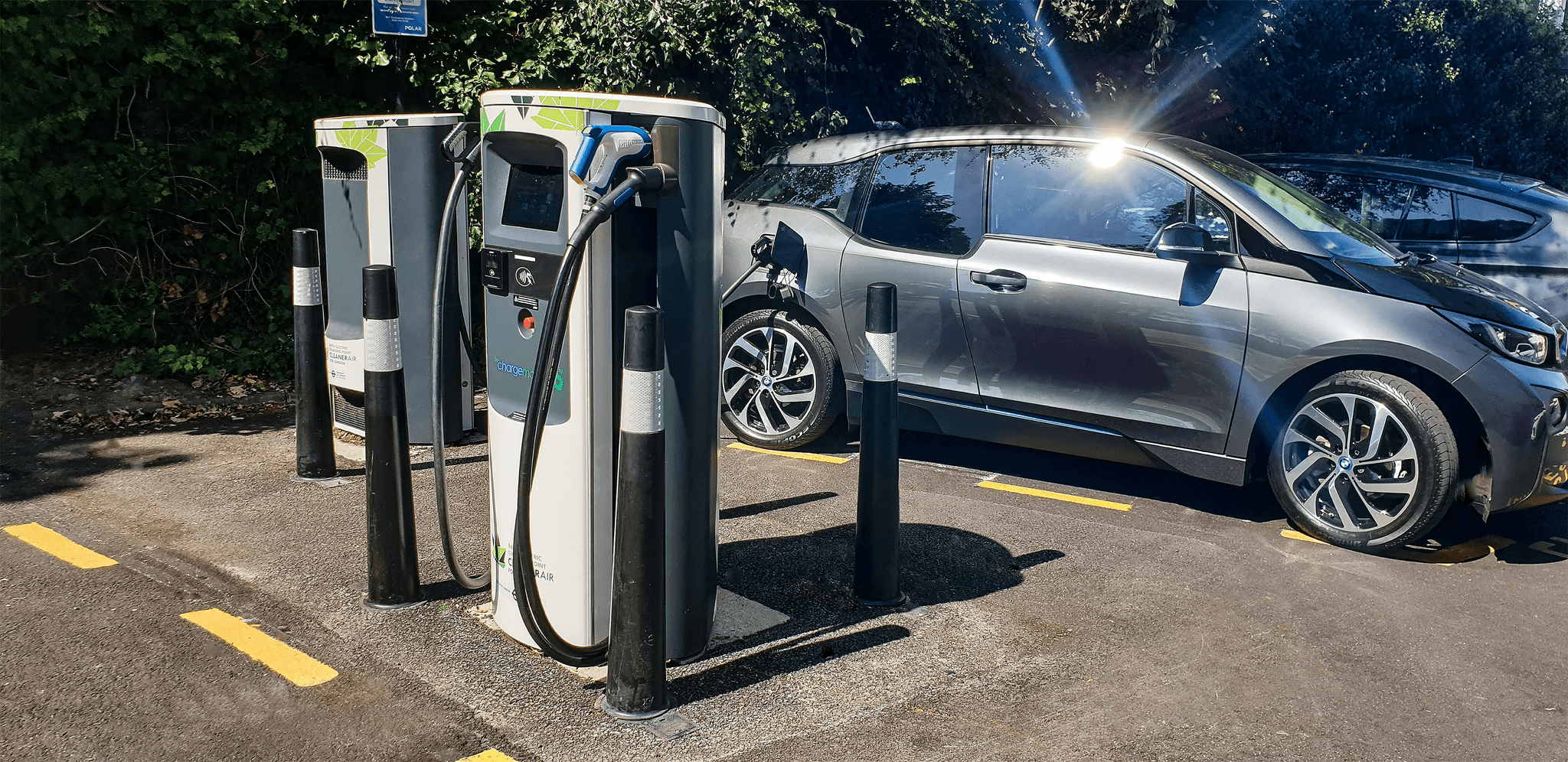 Electric car manufacturers list - Array of Nissan Leaf vehicles at charging stations