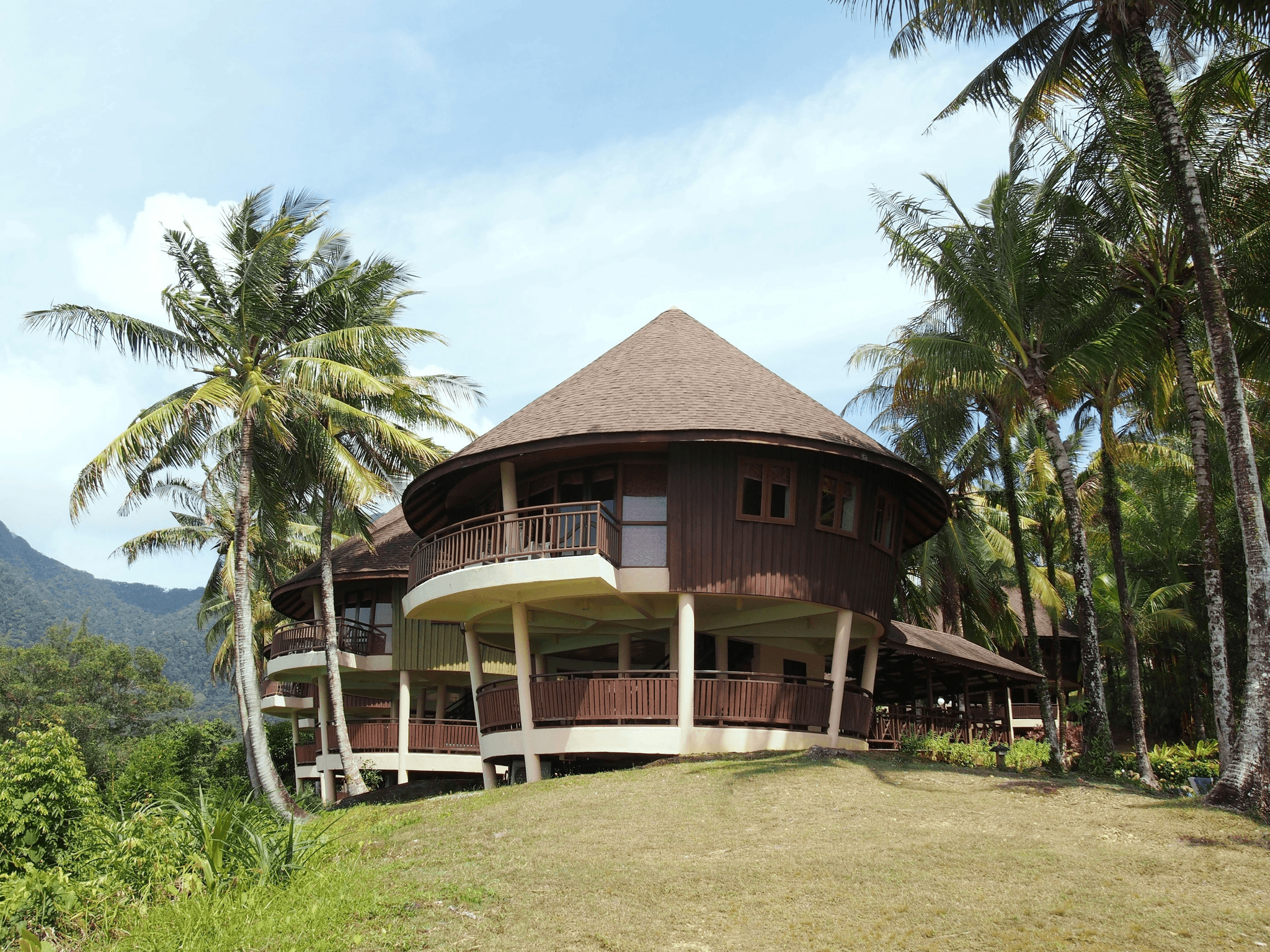 This image shows a circular Indonesian villa concept in a mountainous region.