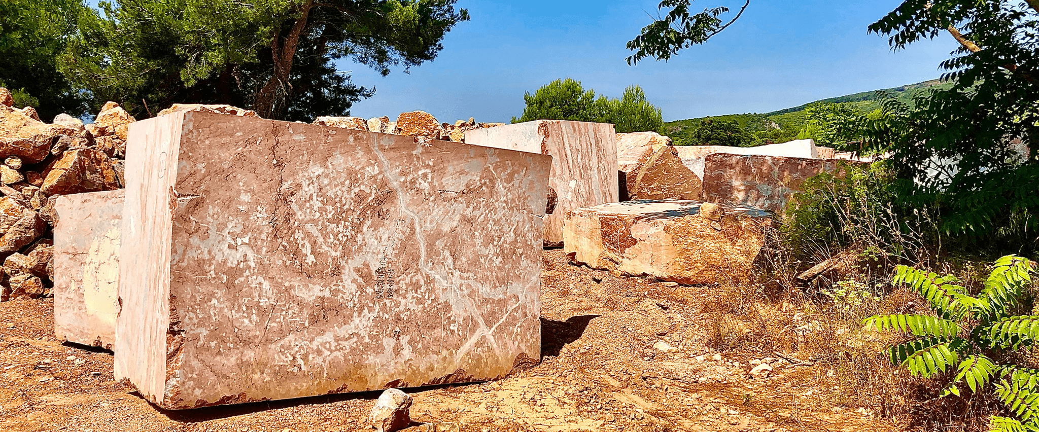 Person inspecting different types of natural stones at a stone yard while researching types of stone for building houses