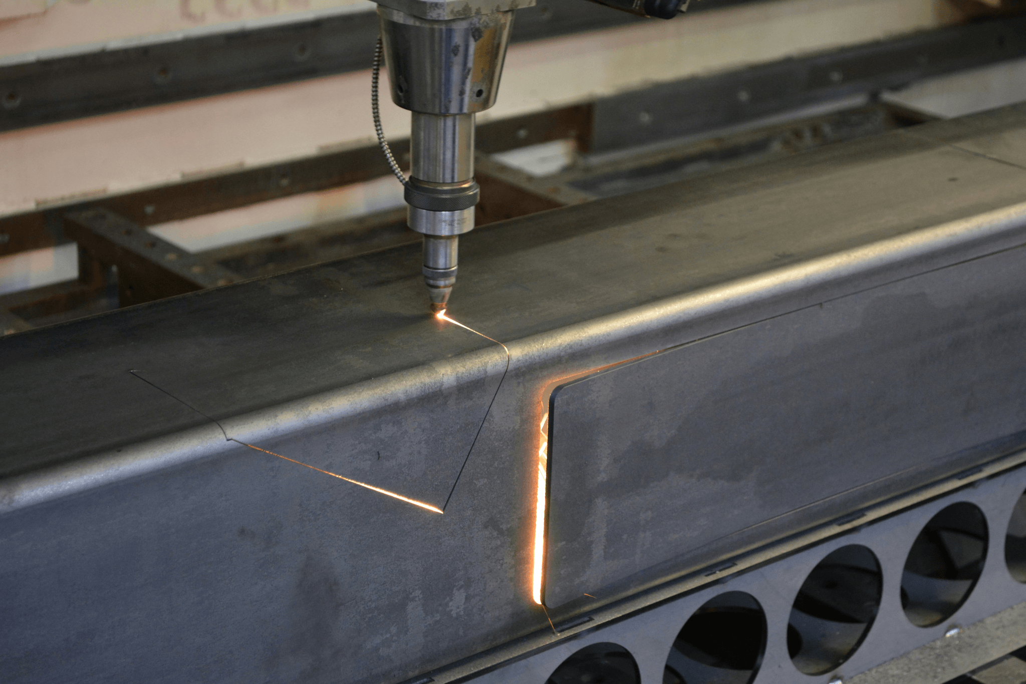 Industrial CNC machine cutting metal - which type of manufacturing involves removing material to make a finished product?