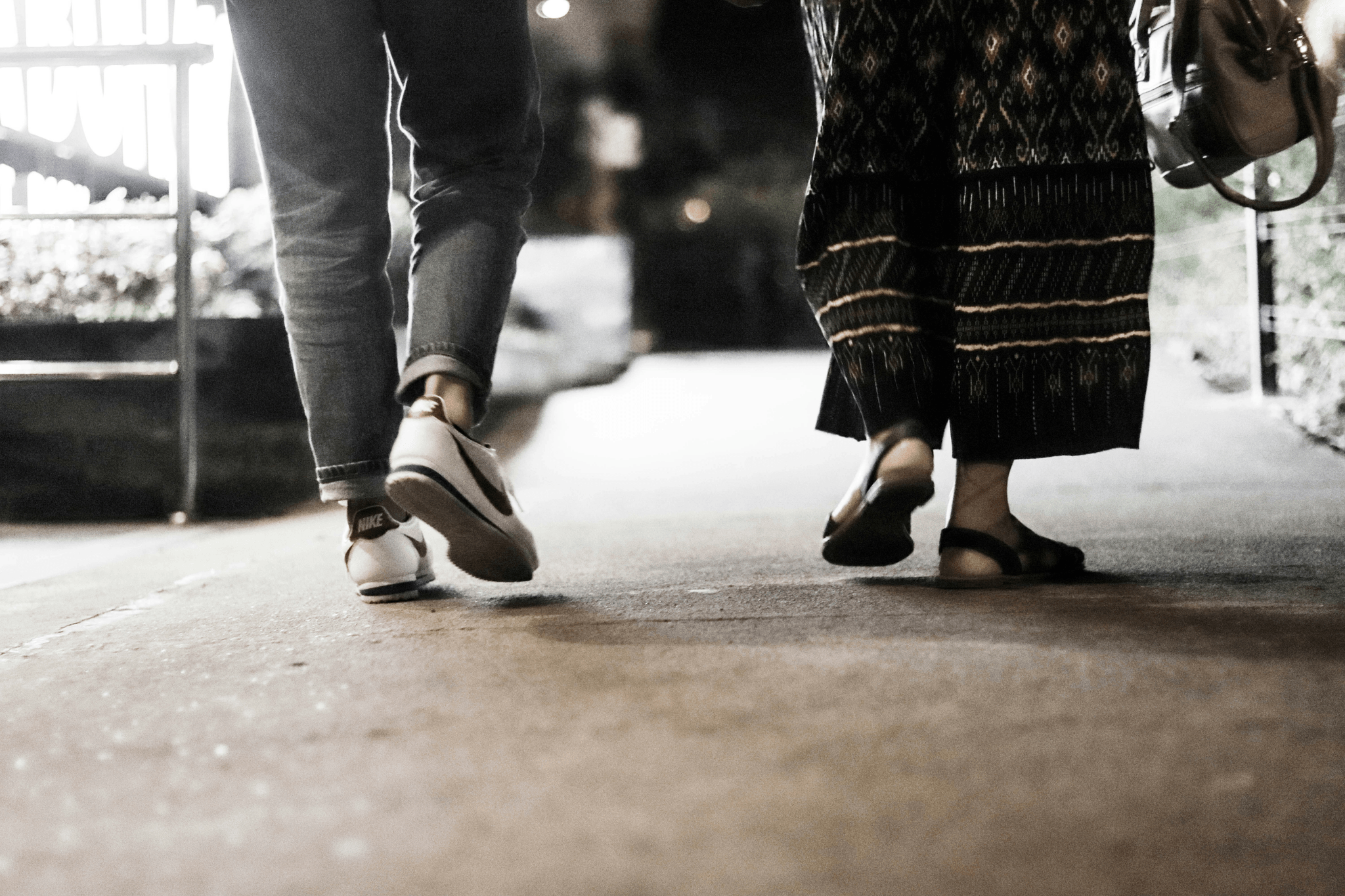 The feet of two people walking side by side