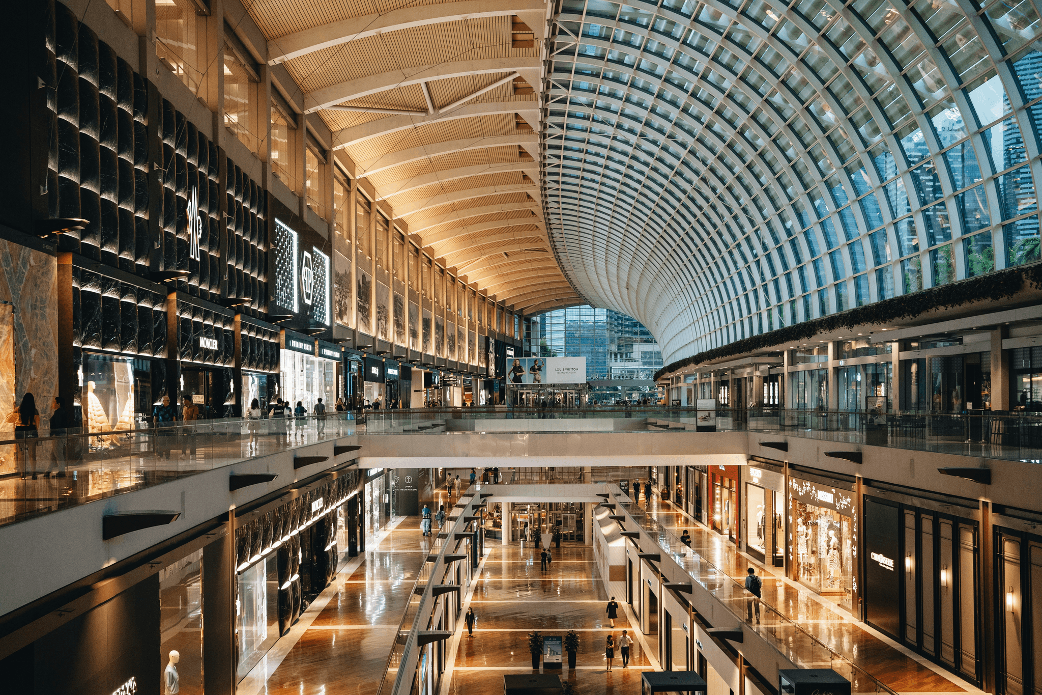 Modern mall escalator connecting floors in busy shopping environment.