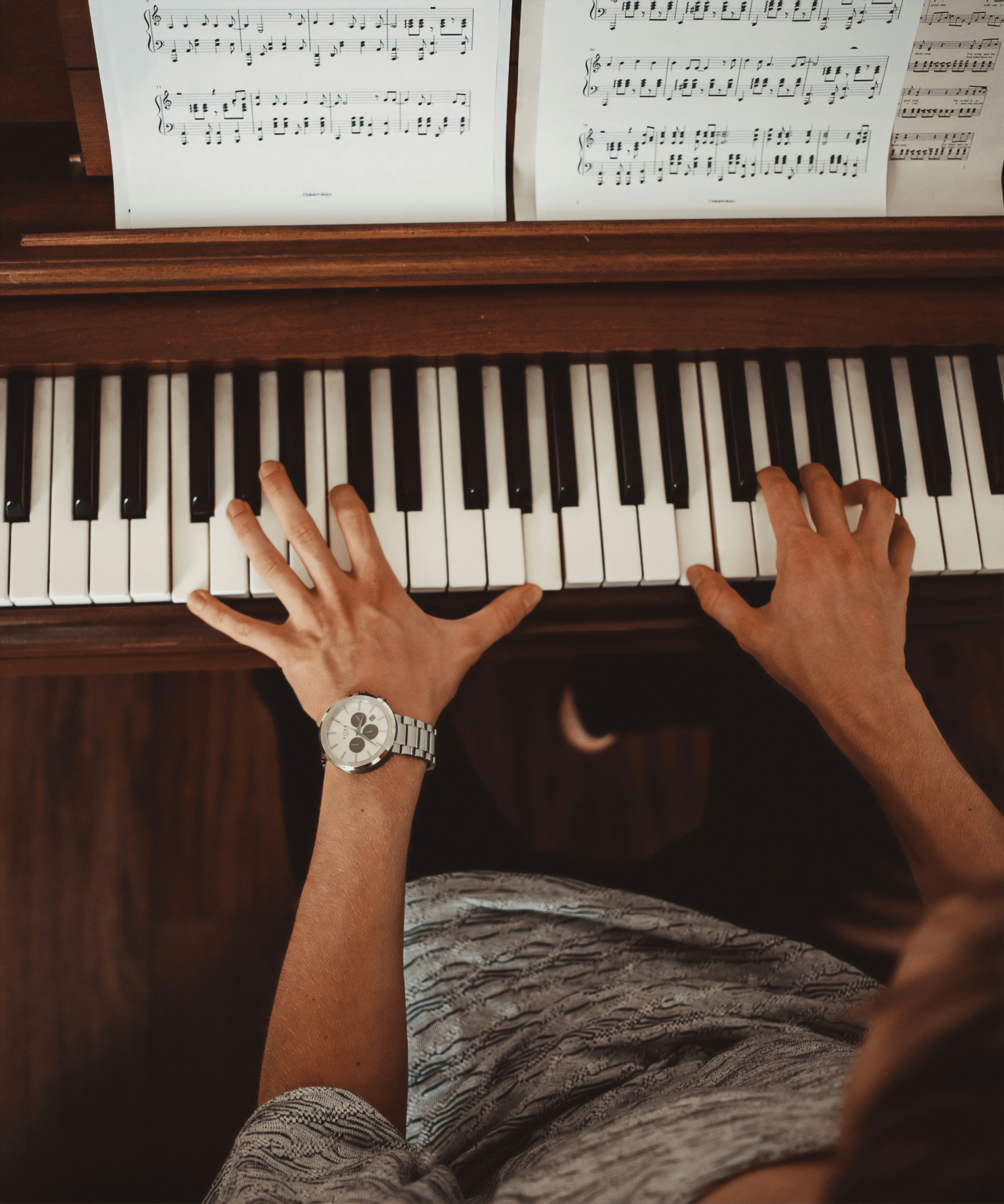 a lady plays piano on a wooden piano