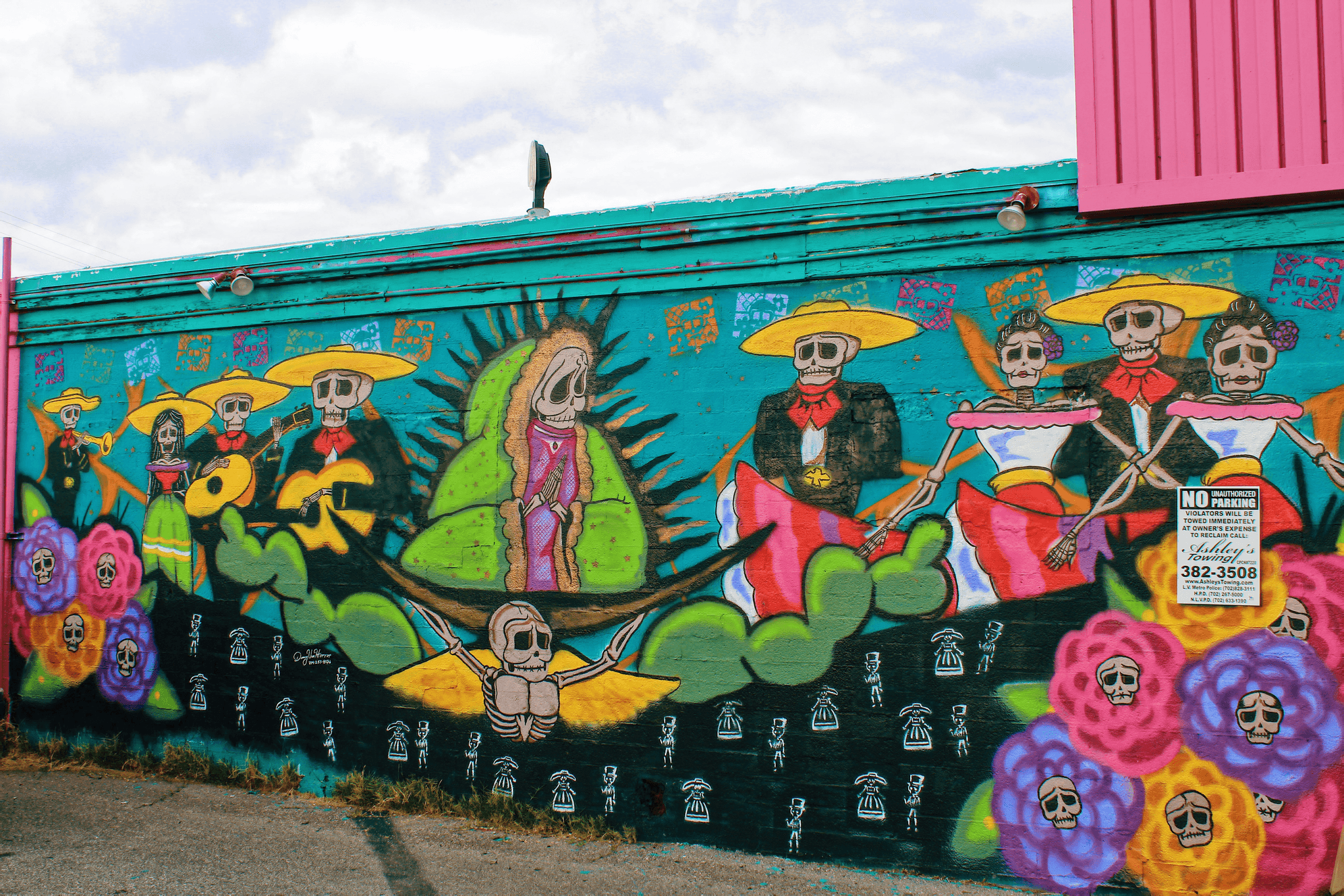 Latino street mural art inspired by Day of the Dead featuring skeleton musicians and cultural symbols.