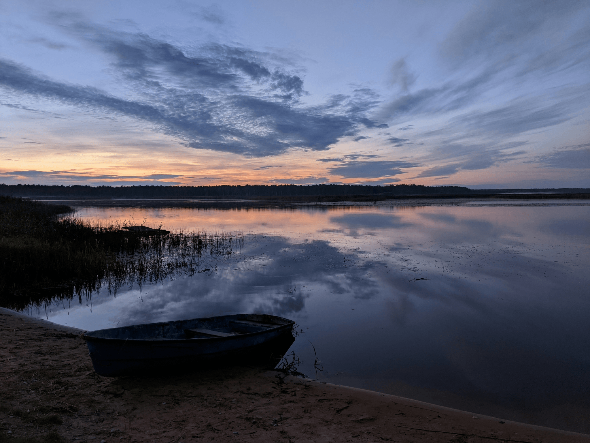 Lightweight aluminum boats by serene lake at sunset.