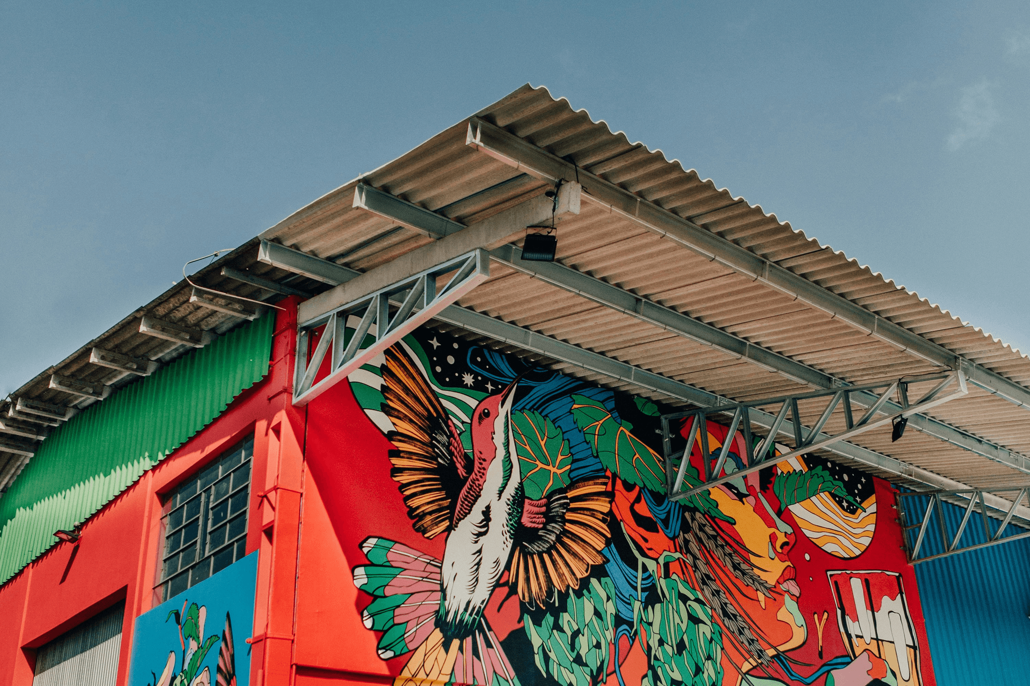 Local artist painting vibrant mural on freight container homes