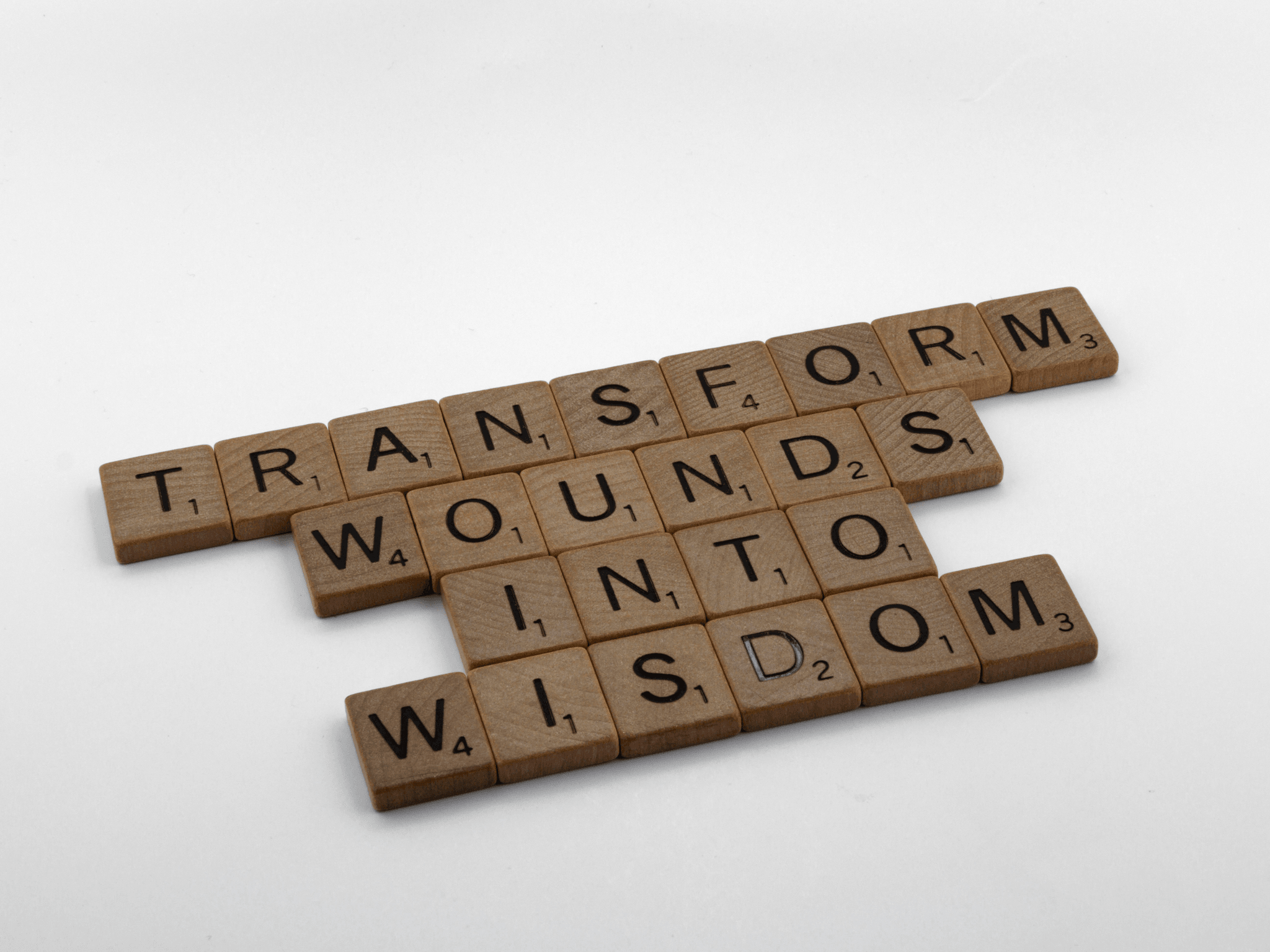 scrabble tiles that spell:  Transform Wounds Into Wisdom