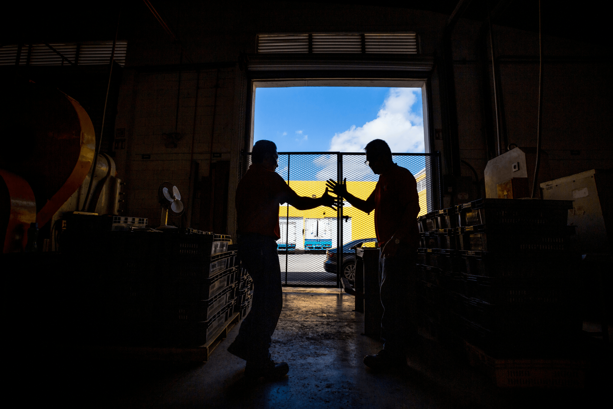 Two businessmen shaking hands over a contract for prefabricated warehouse financing.