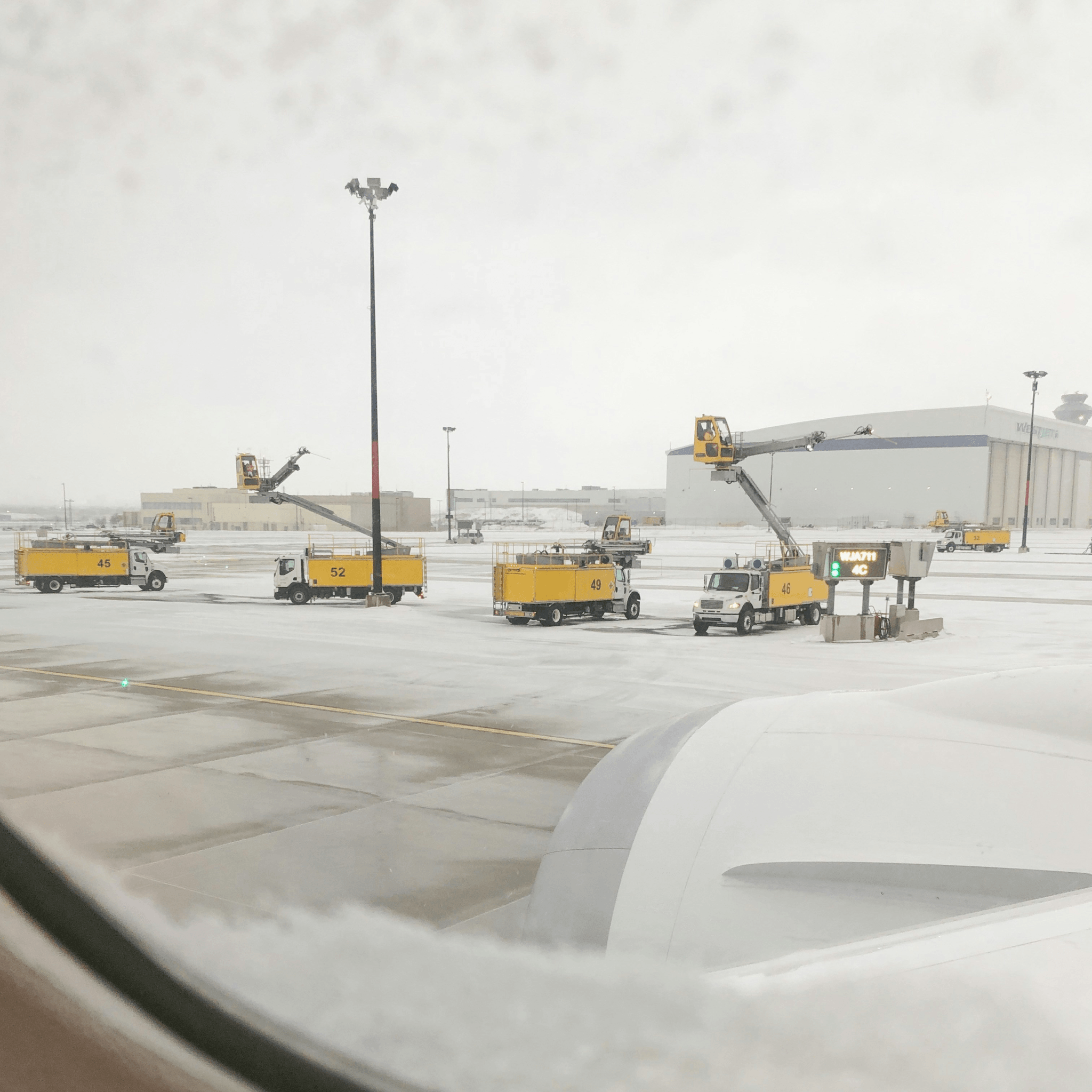truck mounted snow blower clearing runway at an airport