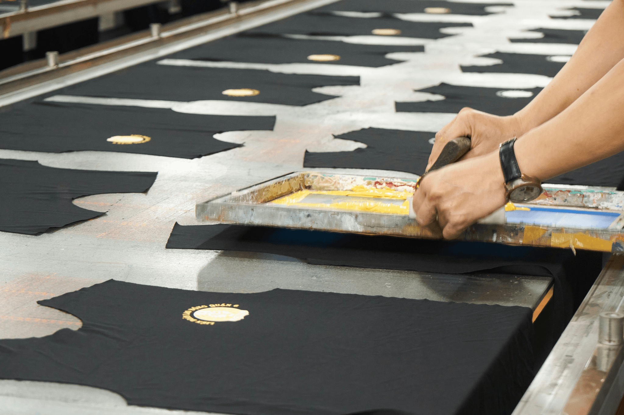 Modernized shirt printing facility using automation technology for efficient shirt printing on demand.