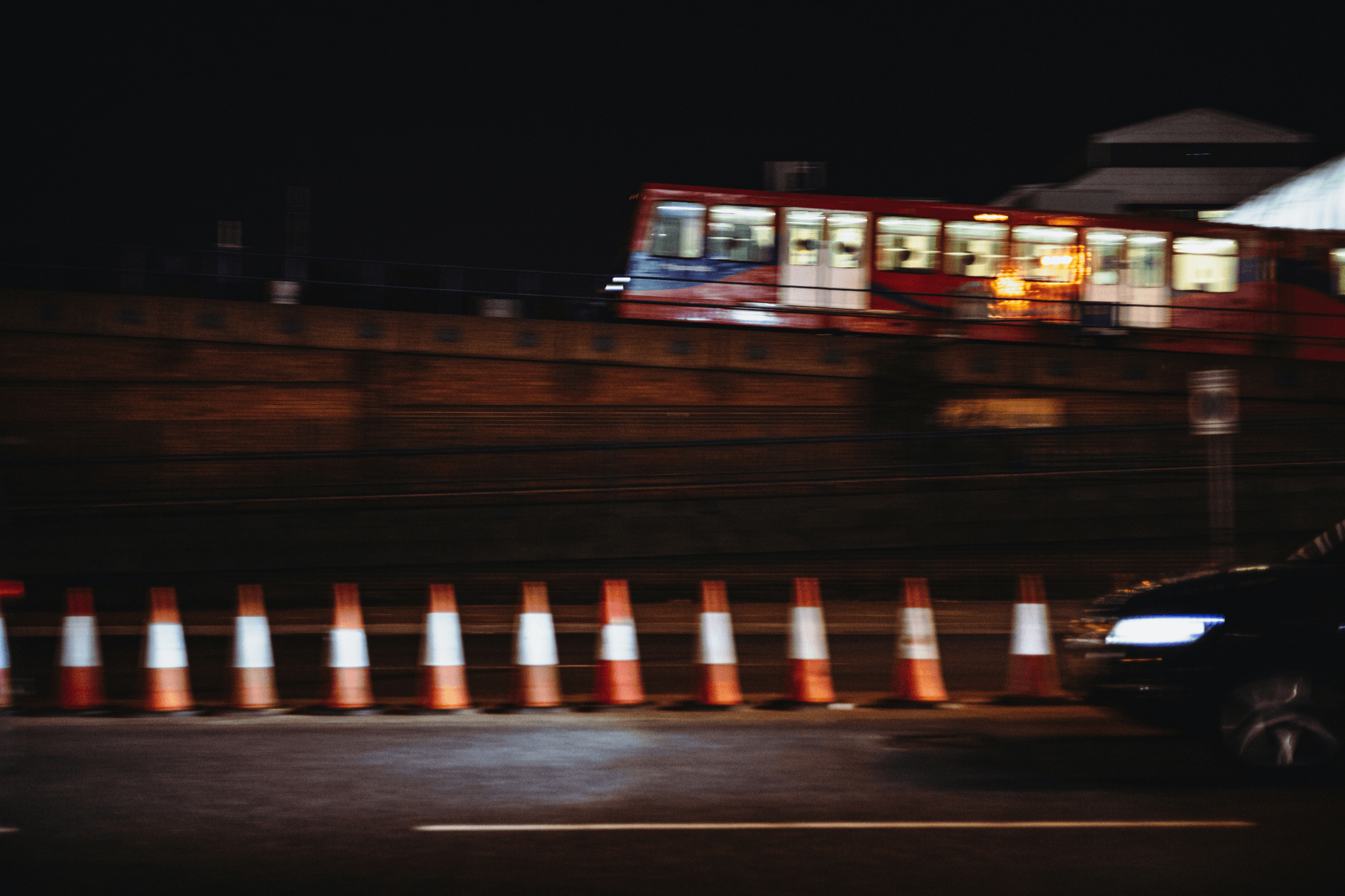 a street at night blocked by a barrier of cones