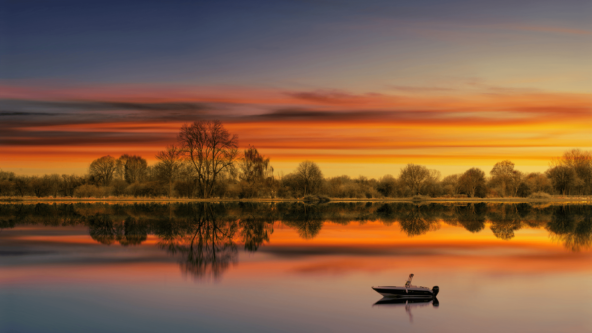Tranquil scene of small aluminum fishing boat on serene lake