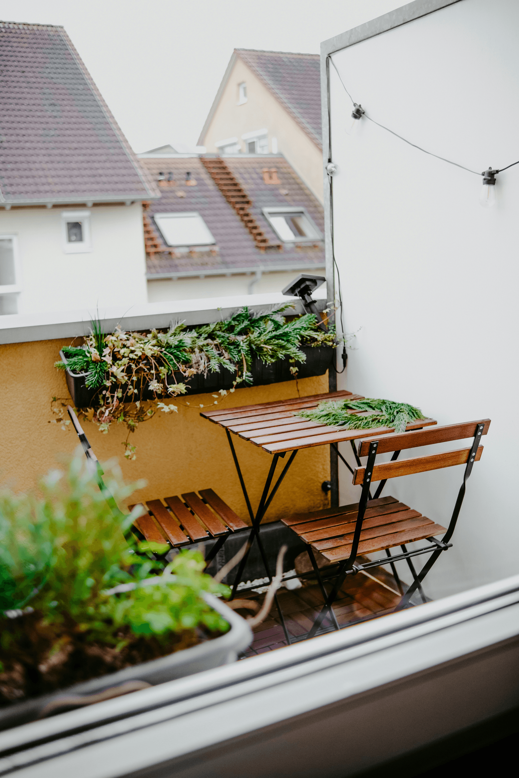 long garden ideas with decking showcasing foldable furniture and vertical gardening