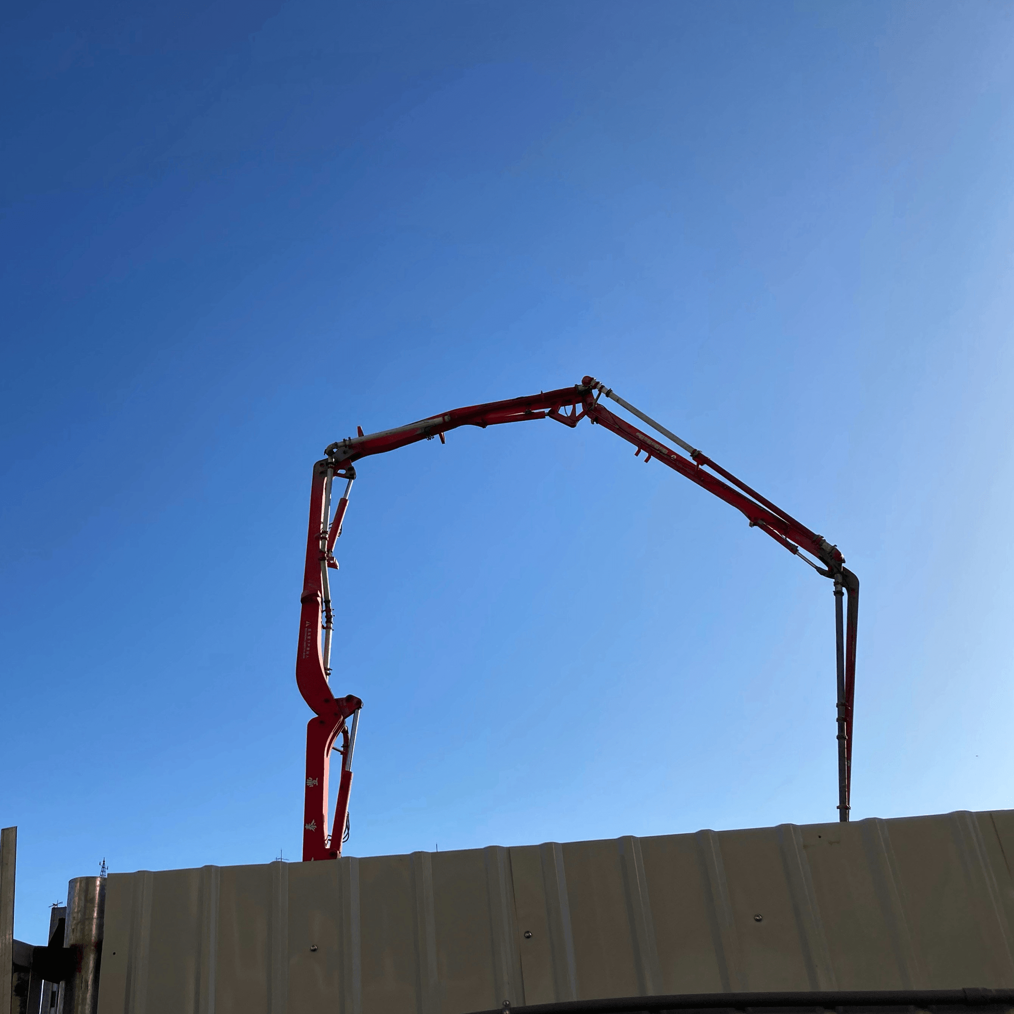 Construction container being lifted by crane at a busy construction site