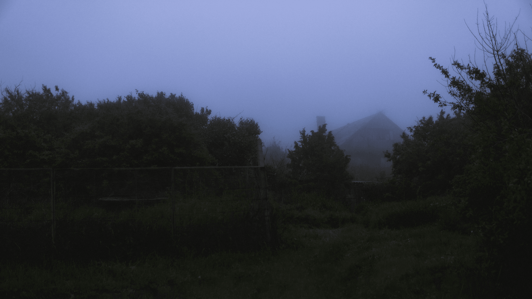 Apple Cabin Haunted House exterior at night with fog