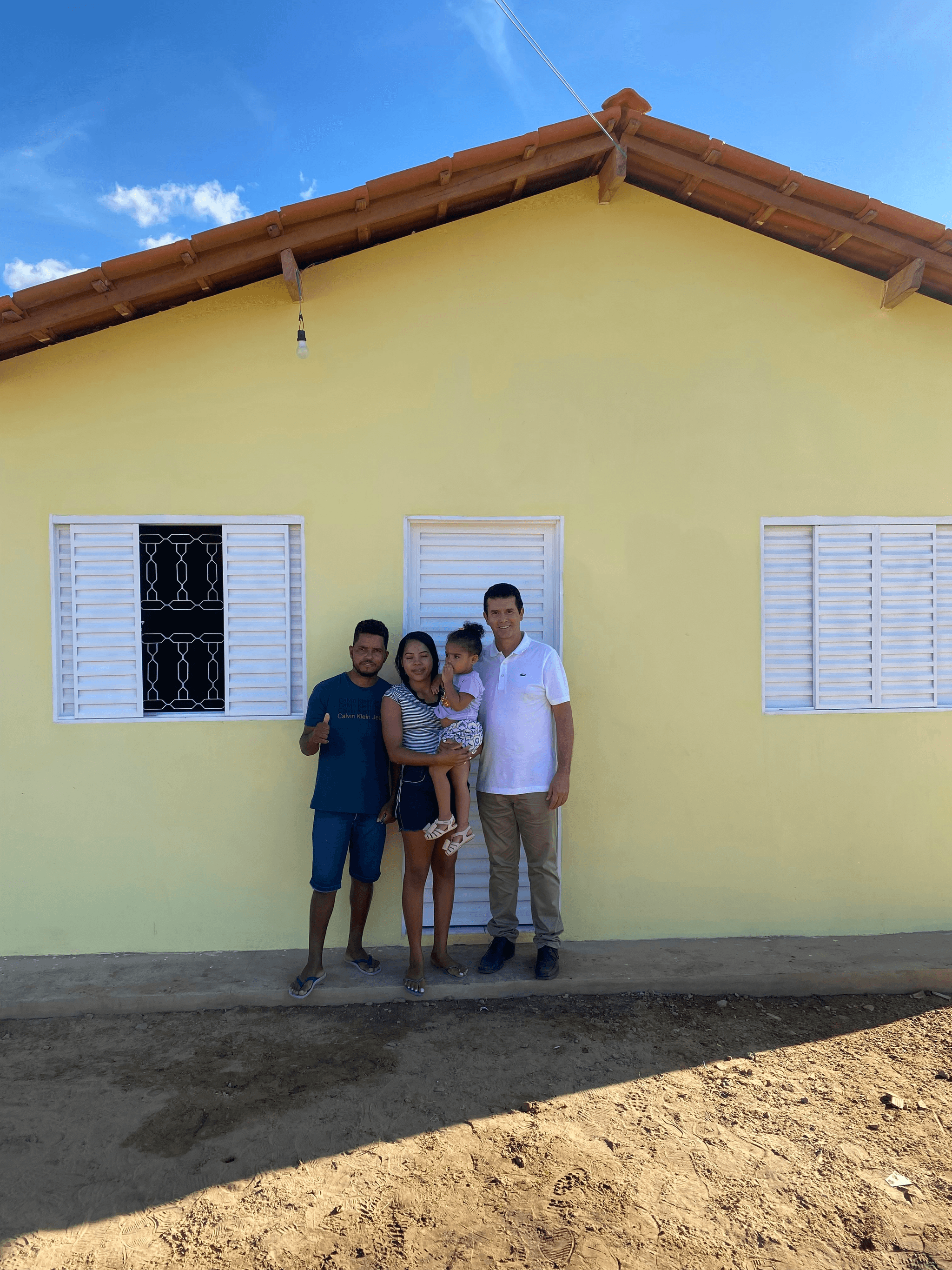 buy prefabricated house - happy family standing in front of their new home