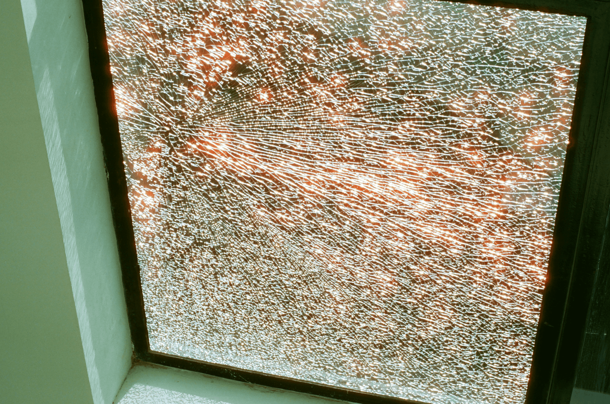 Close-up of a broken glass window with spiderweb cracks - window repair and replacement in Reading, PA.