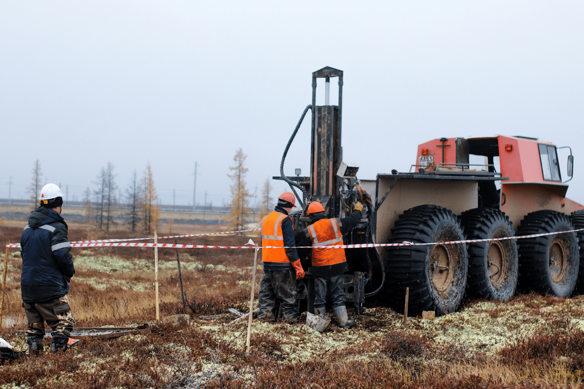 Workers operating heavy machinery in rotary drilling operations