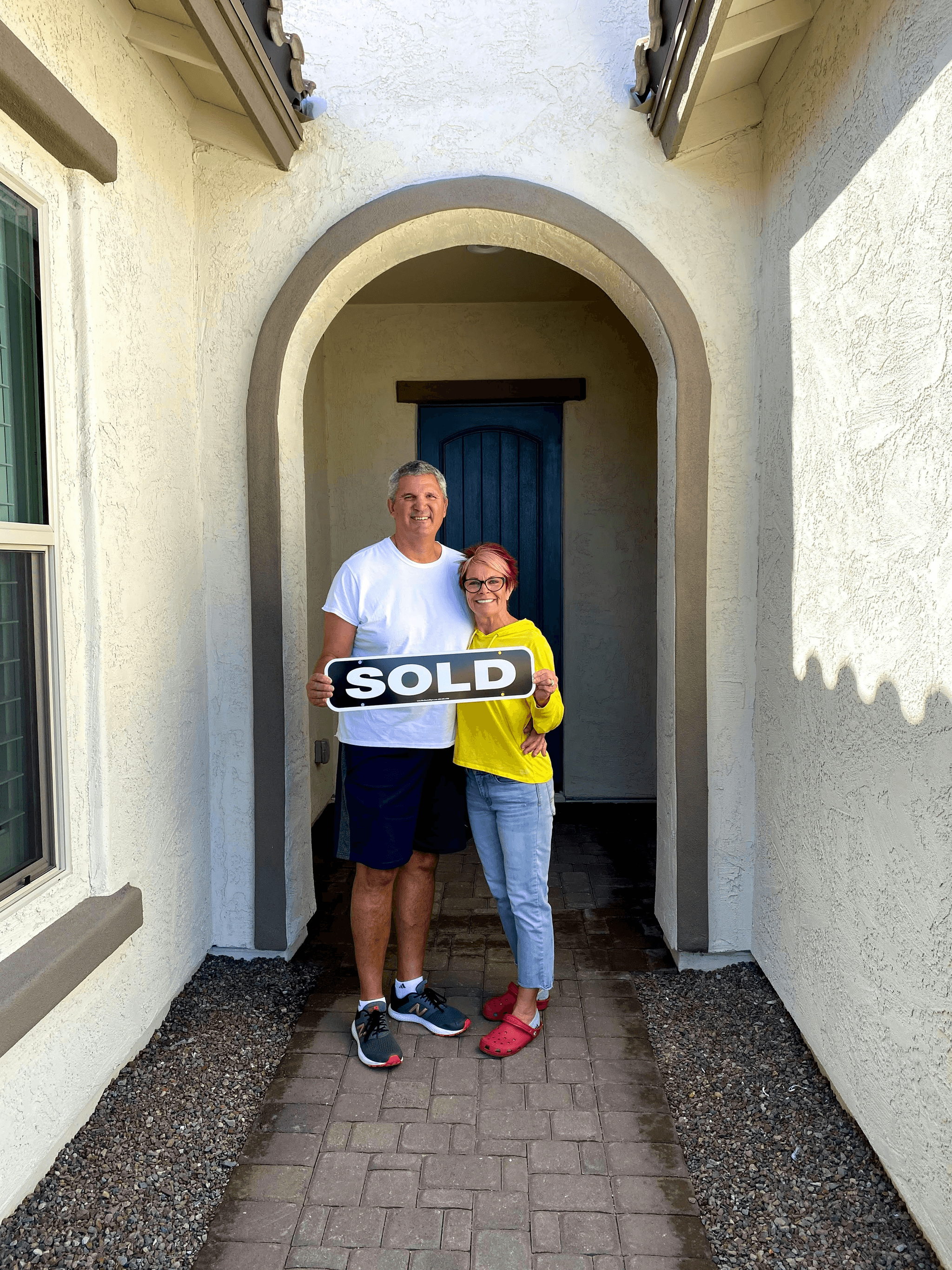 Happy homeowners standing in front of their today homes