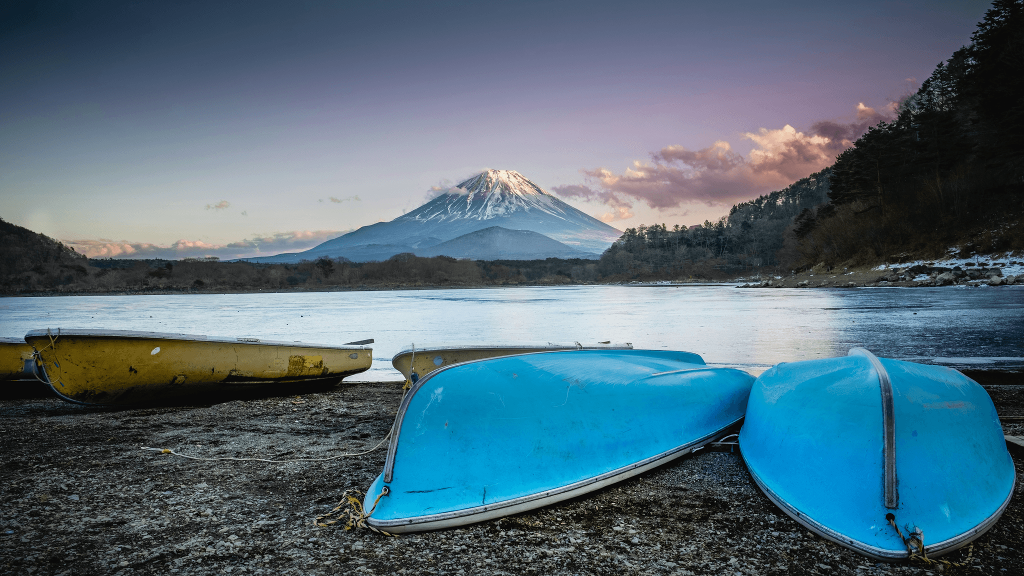 Utility boat types on calm water with mountain view