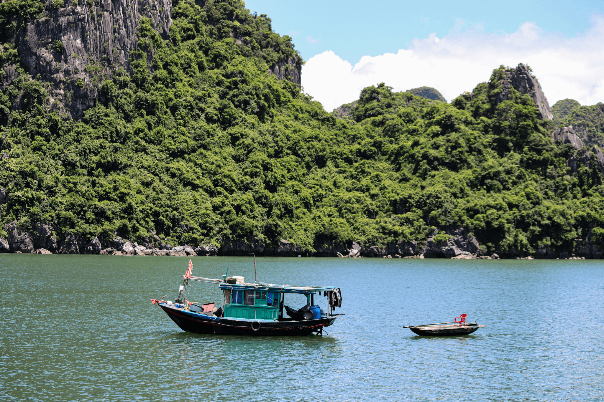 Aluminum v hull boat navigating calm waters with mountain backdrop.